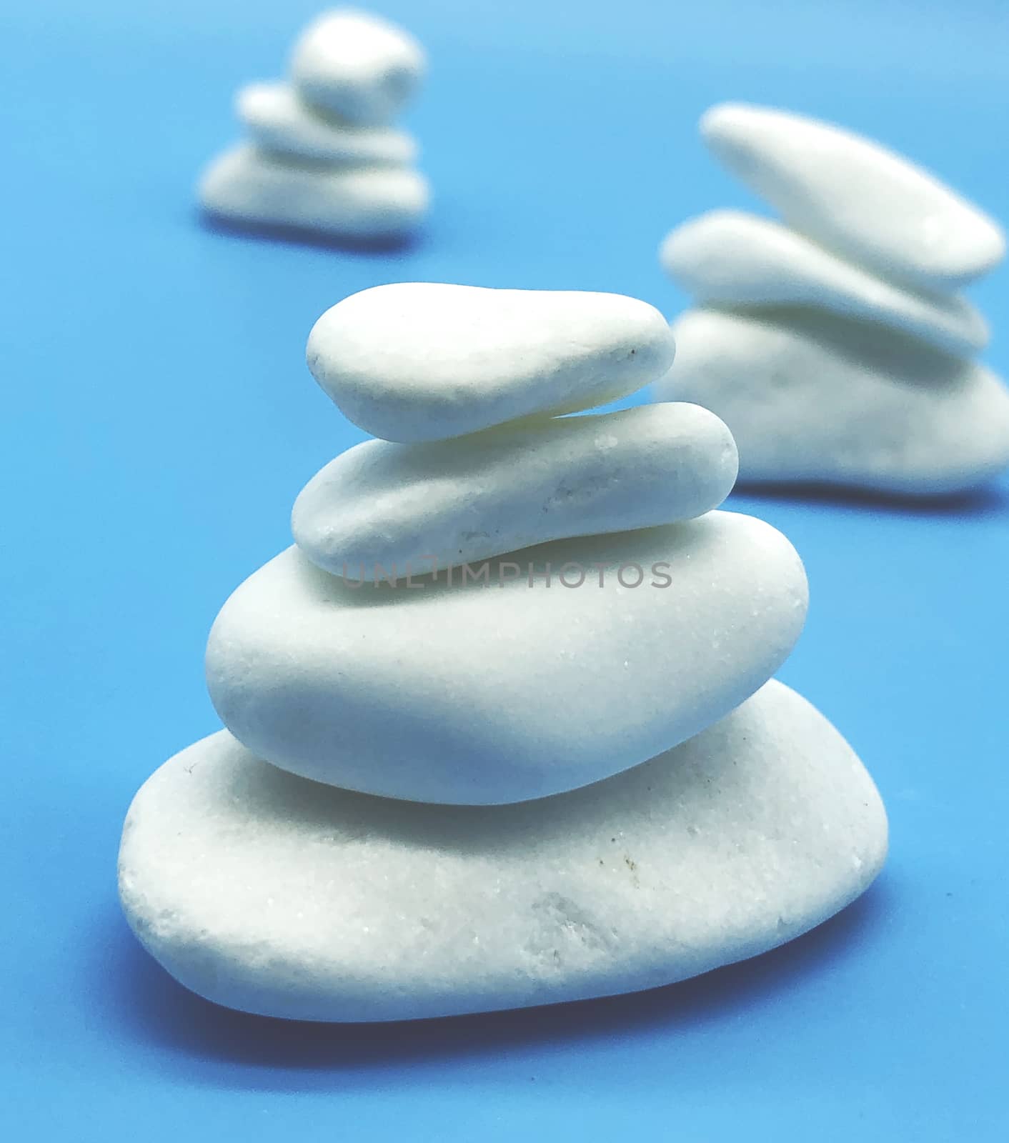 spa relax concept white stones isolated on blue background perspective