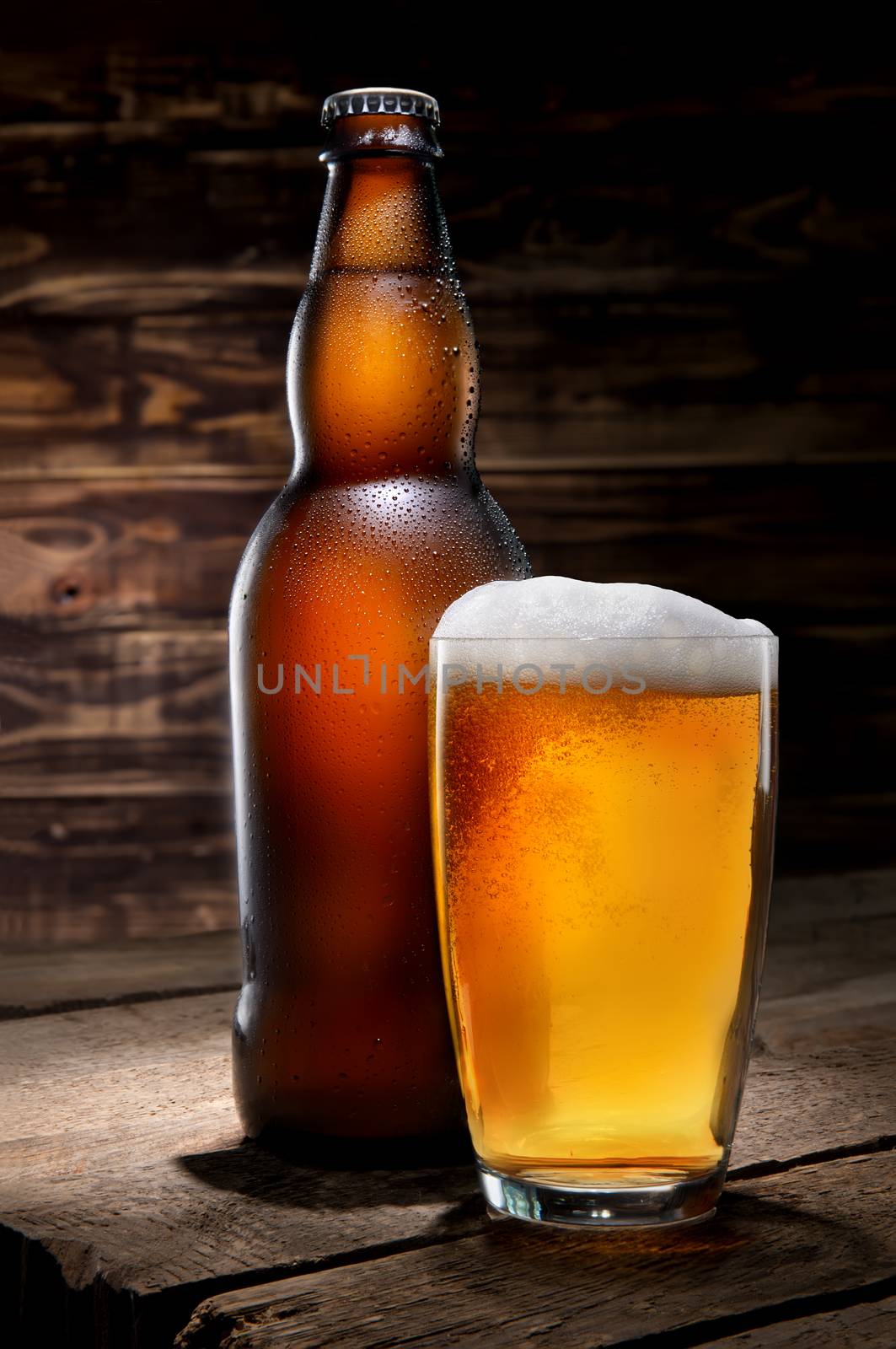 Beer in glass and bottle on wooden background