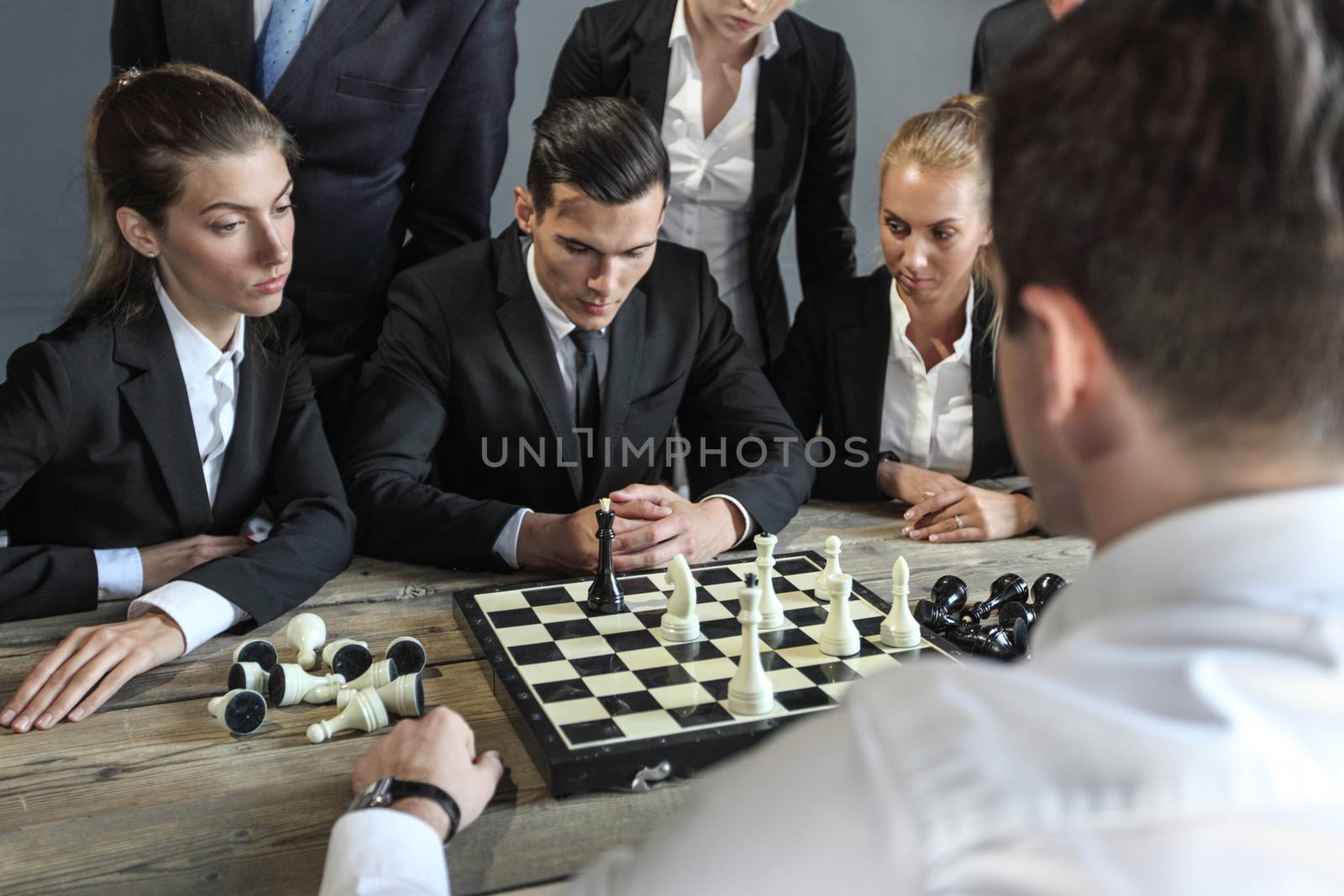 Business people playing chess, team of workers losing, leader is winning