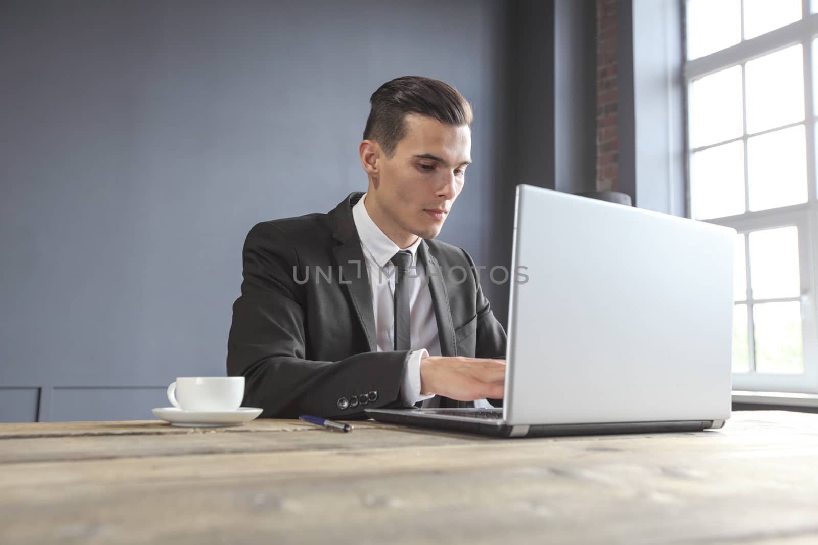 Business man working on a laptop on a rustic wooden table