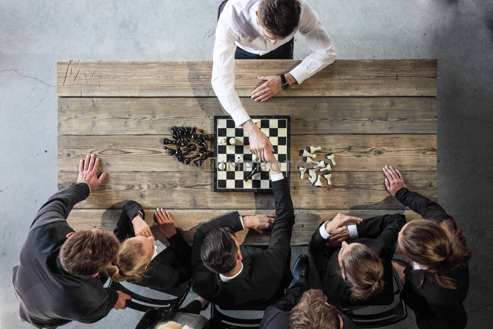 Business people playing chess by ALotOfPeople