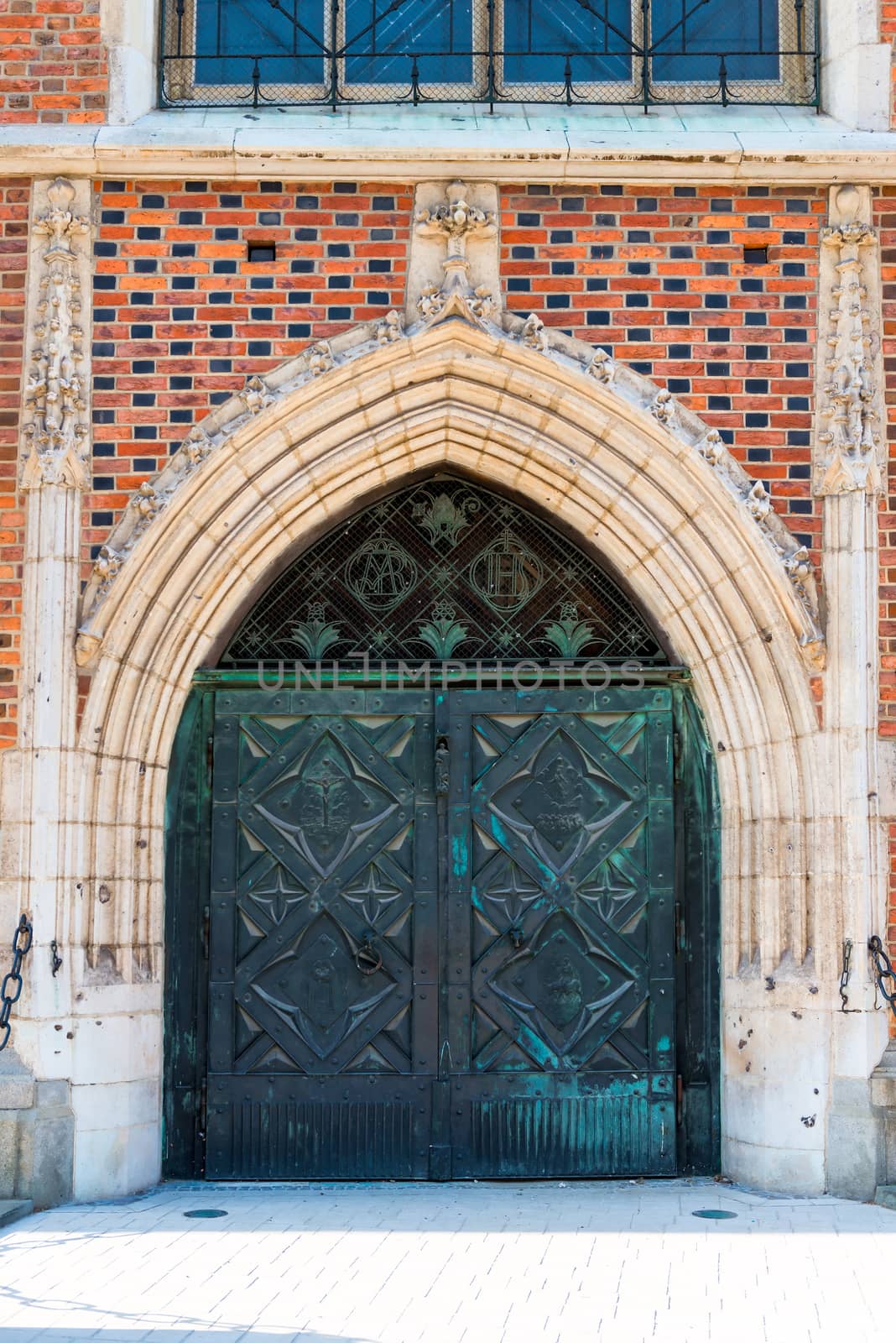 massive metal gate entrance to the brick Catholic church