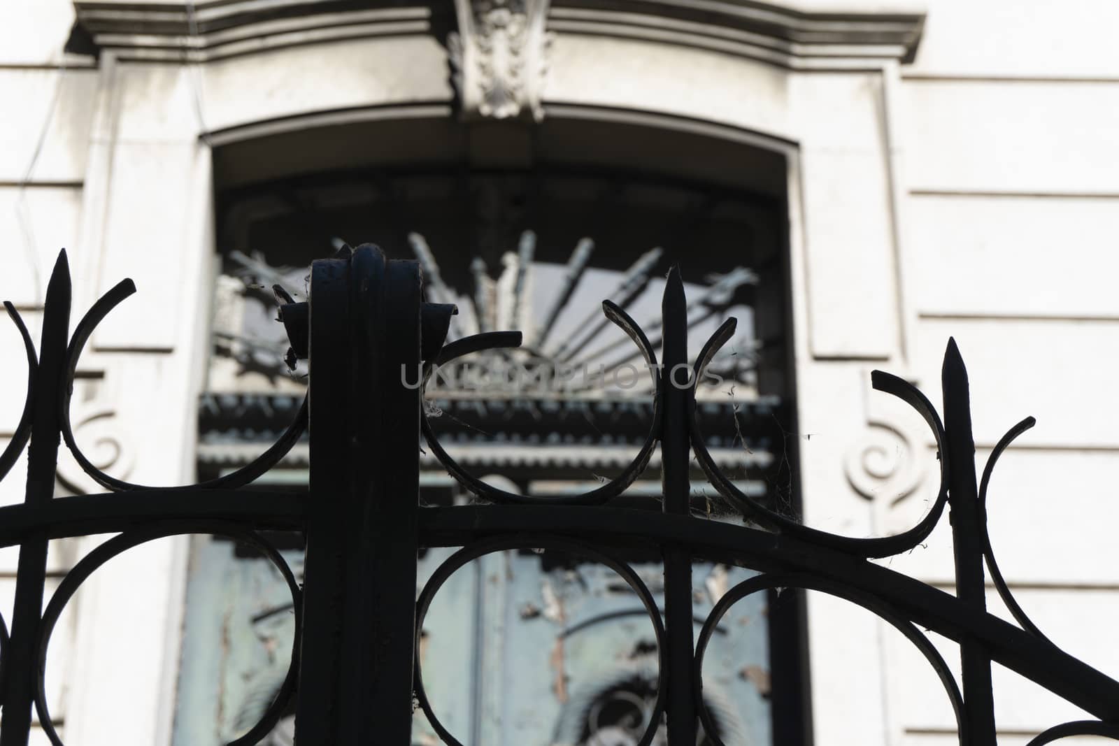 looks from the outside behind iron gate ancient and carved in Gothic style