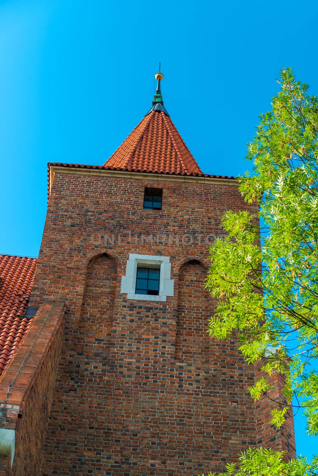 brick Catholic church wall and roof on sky background