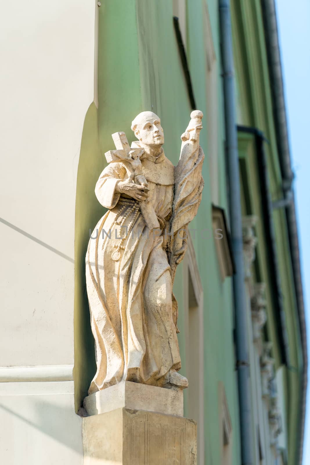 sculpture of the Catholic priest on the facade of the building of the European city