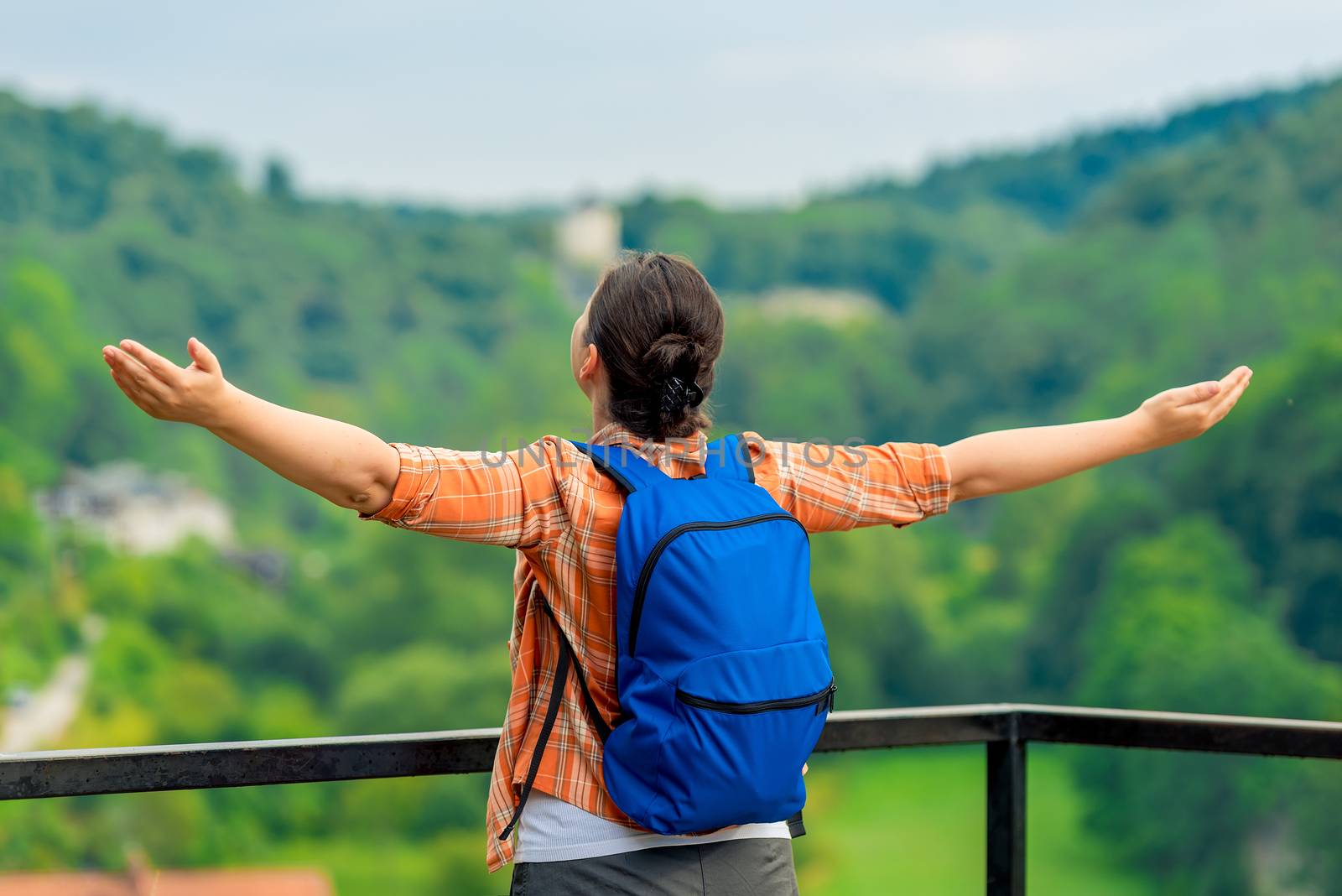woman tourist with arms outstretched enjoys freedom in nature