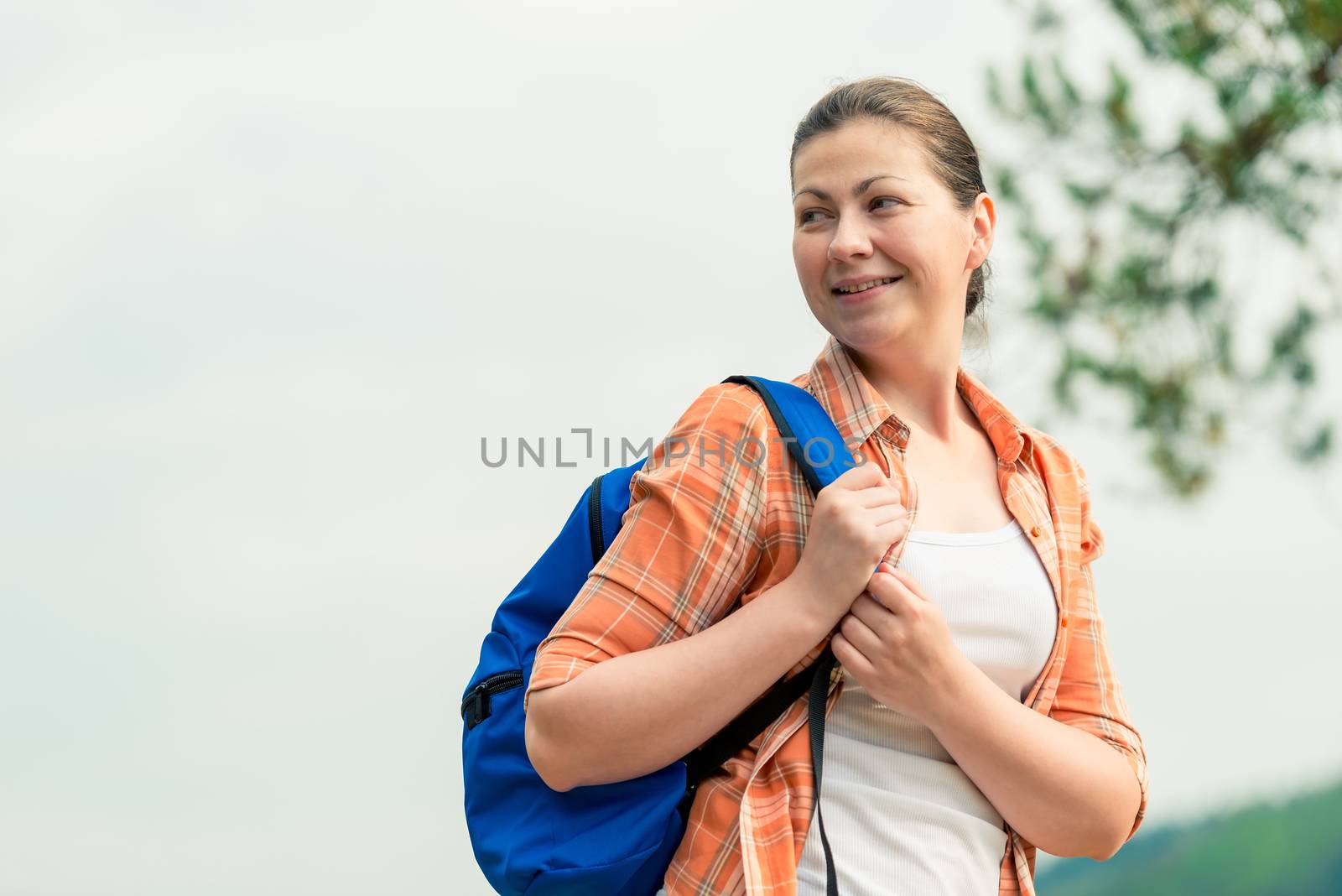 portrait of a tourist with a backpack on the nature in a hike