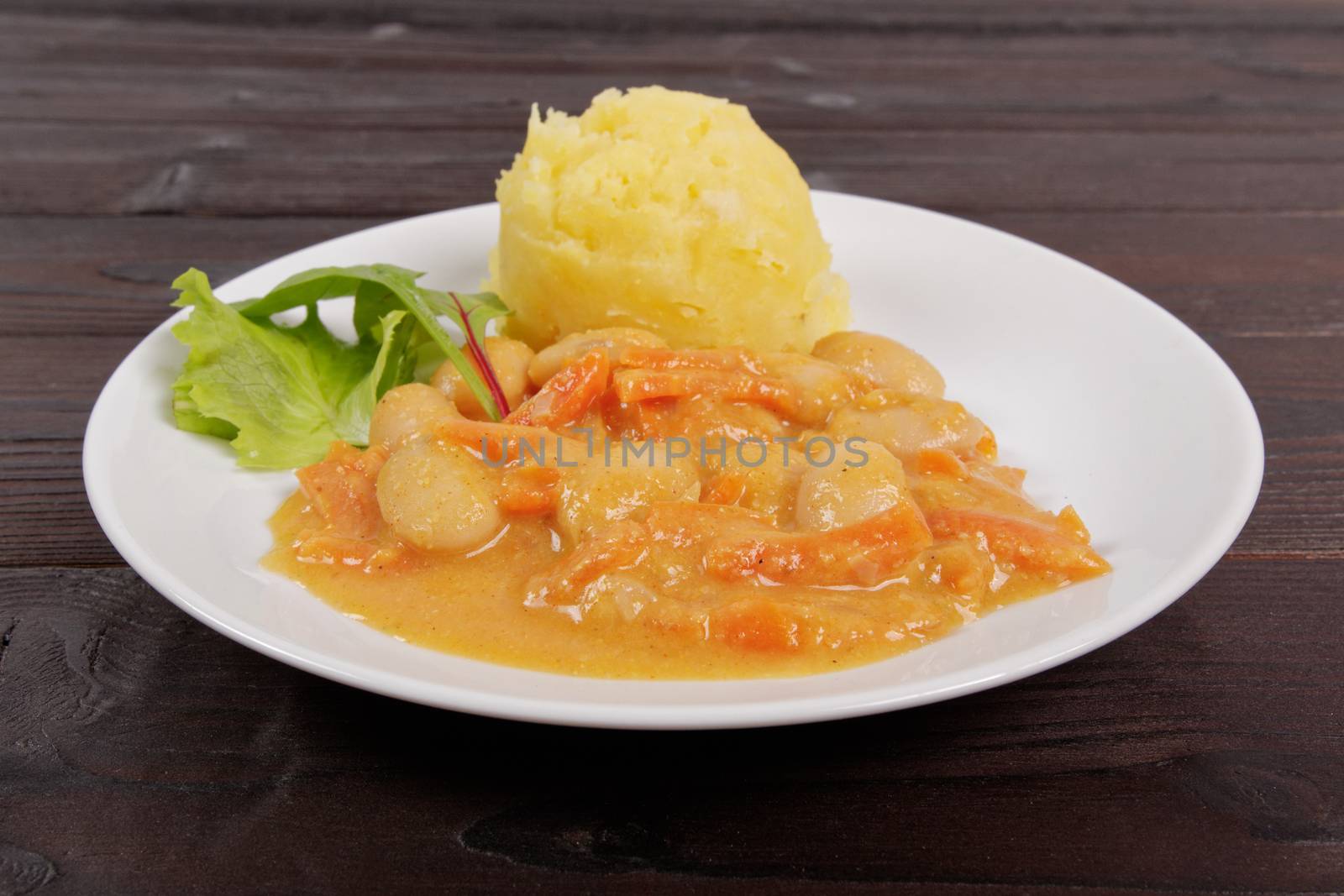 Beans with carrots and potatoes on a wooden table