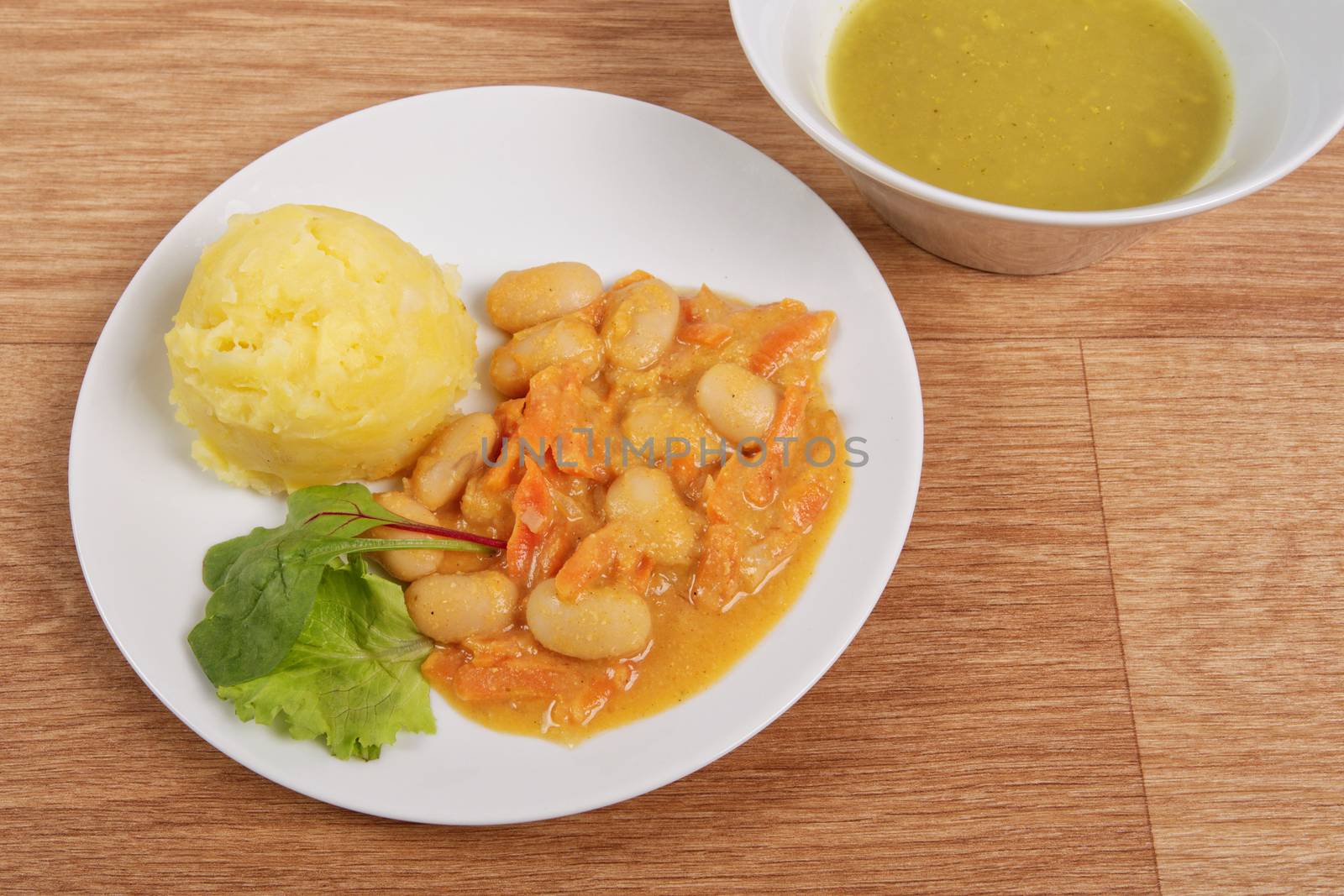 Beans with carrots and potatoes on a wooden table