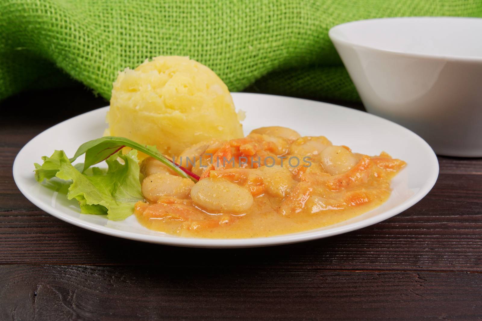 Beans with carrots and potatoes on a wooden table