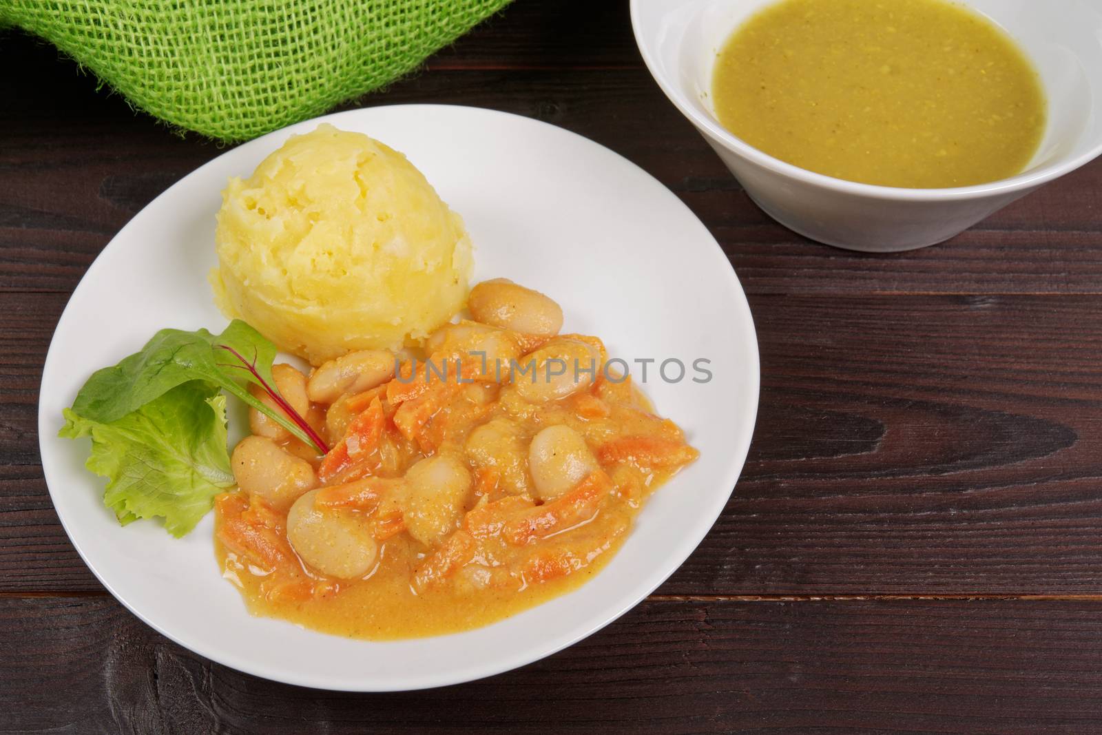 Beans with carrots and potatoes on a wooden table