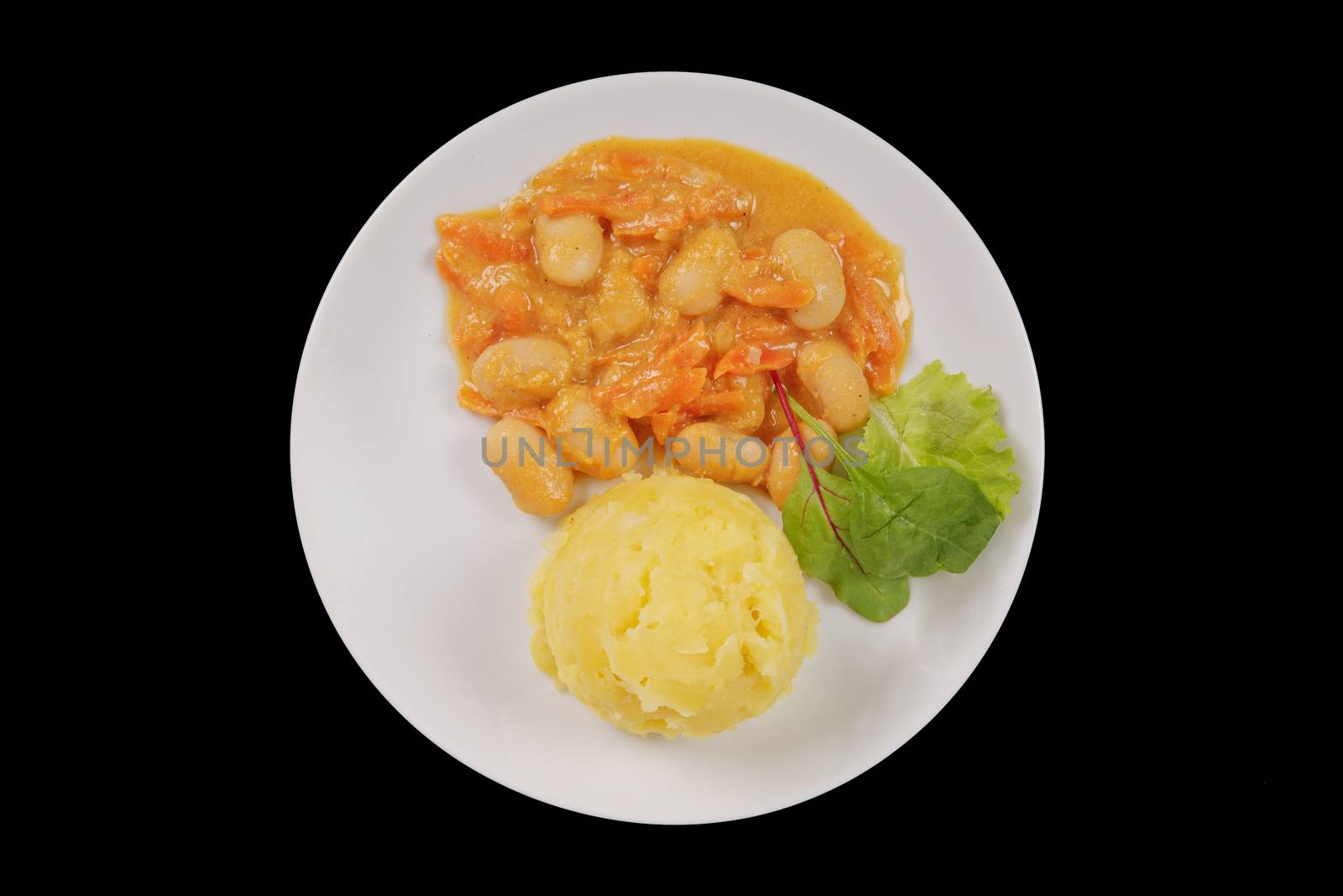 Beans with carrots and potatoes on a black background