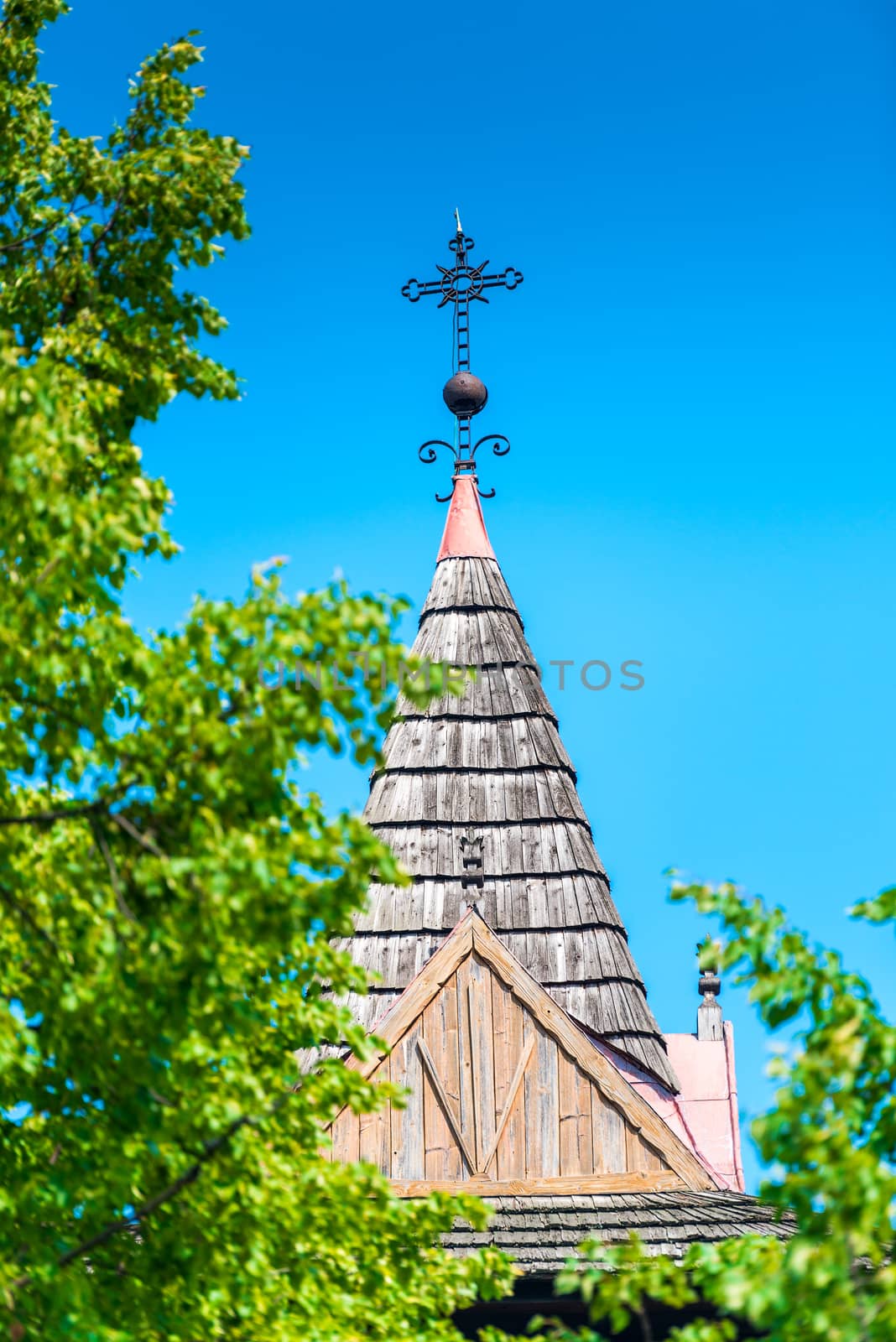 roof of a catholic wooden temple against a blue sky