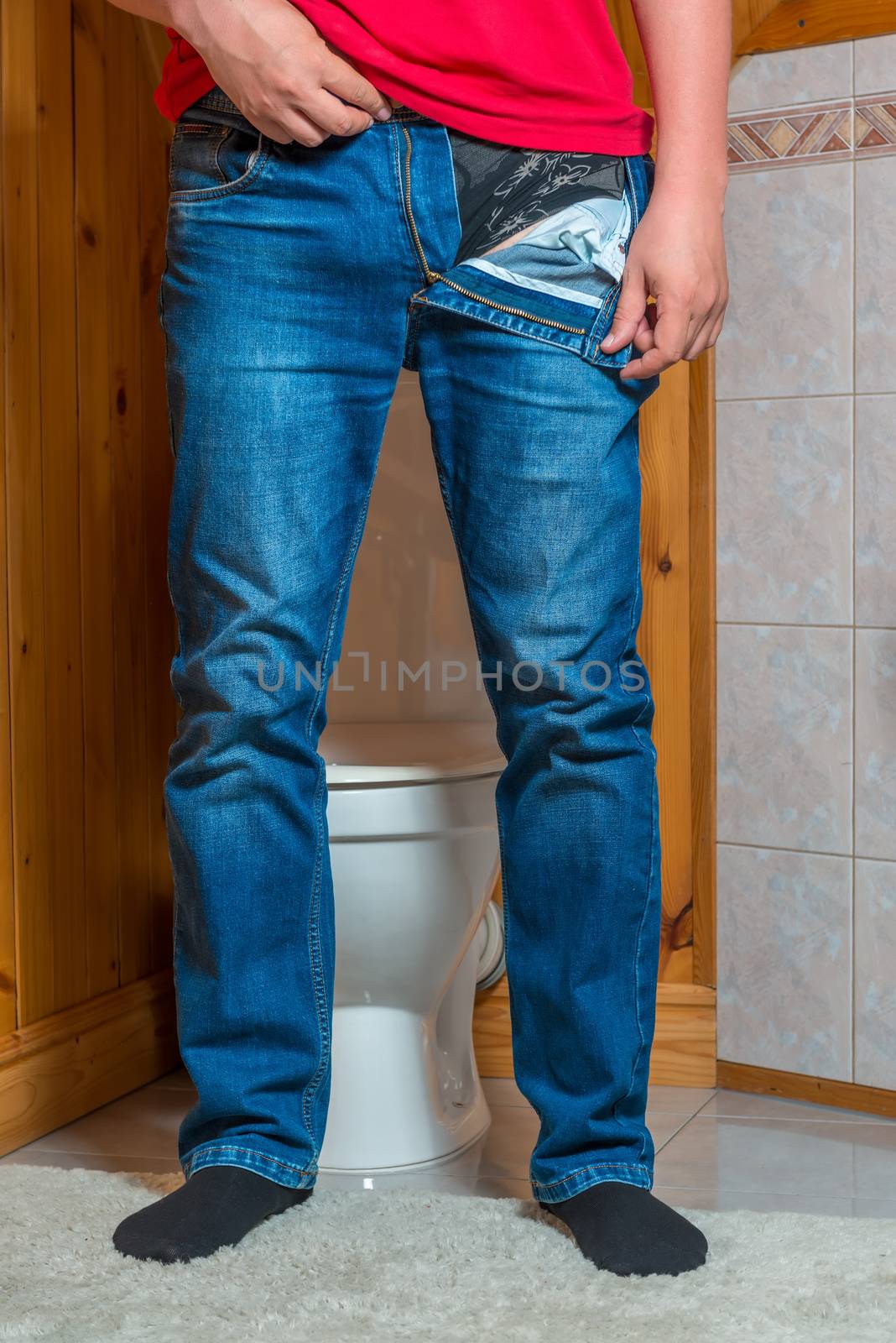 a man takes off his pants in the toilet, a face unrecognizable concept photo