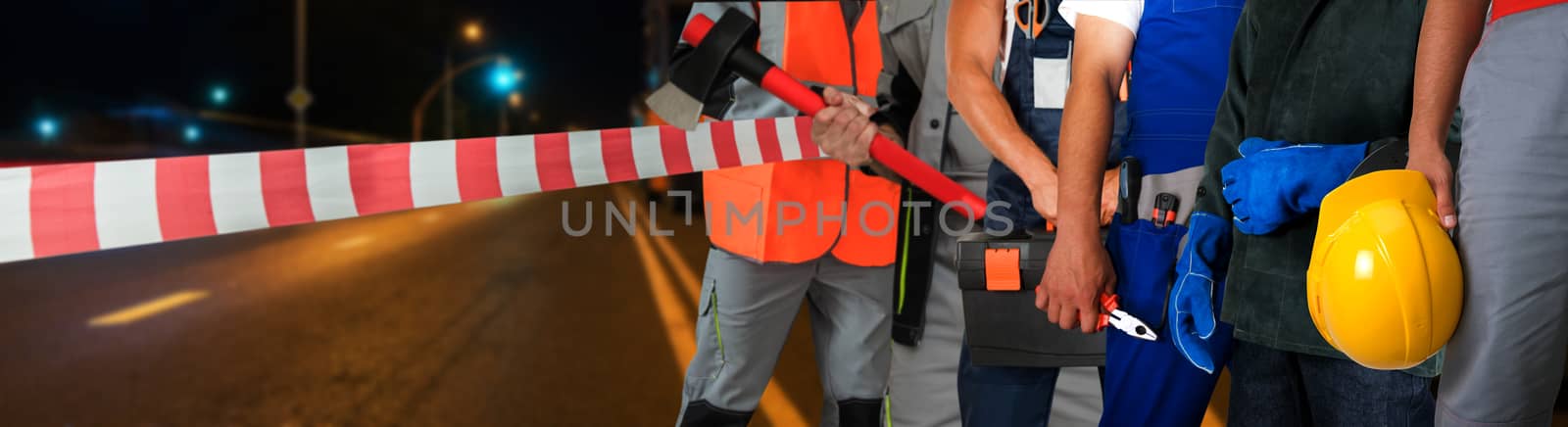 Workers on a road construction, repairing the road in the night city