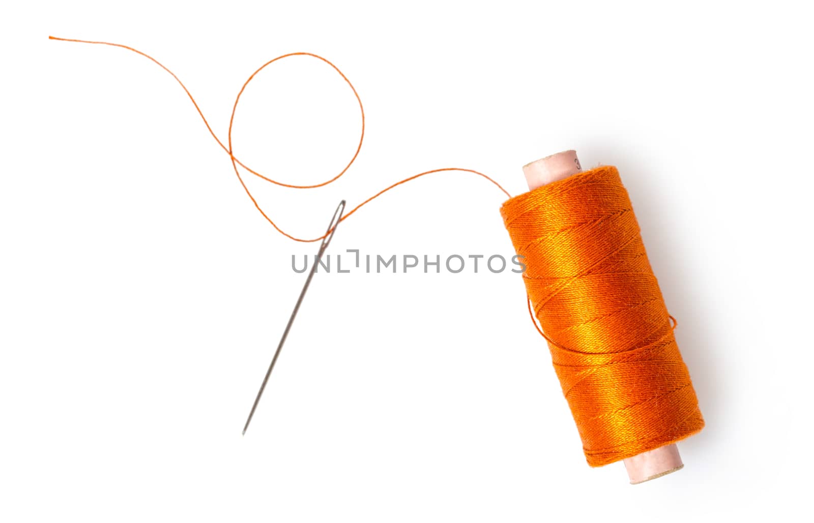 spool of thread with a needle on white isolated background