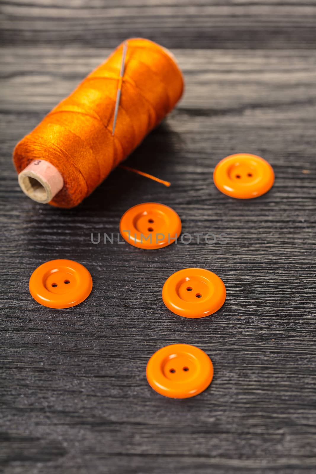 spool of threads and buttons on a wooden background