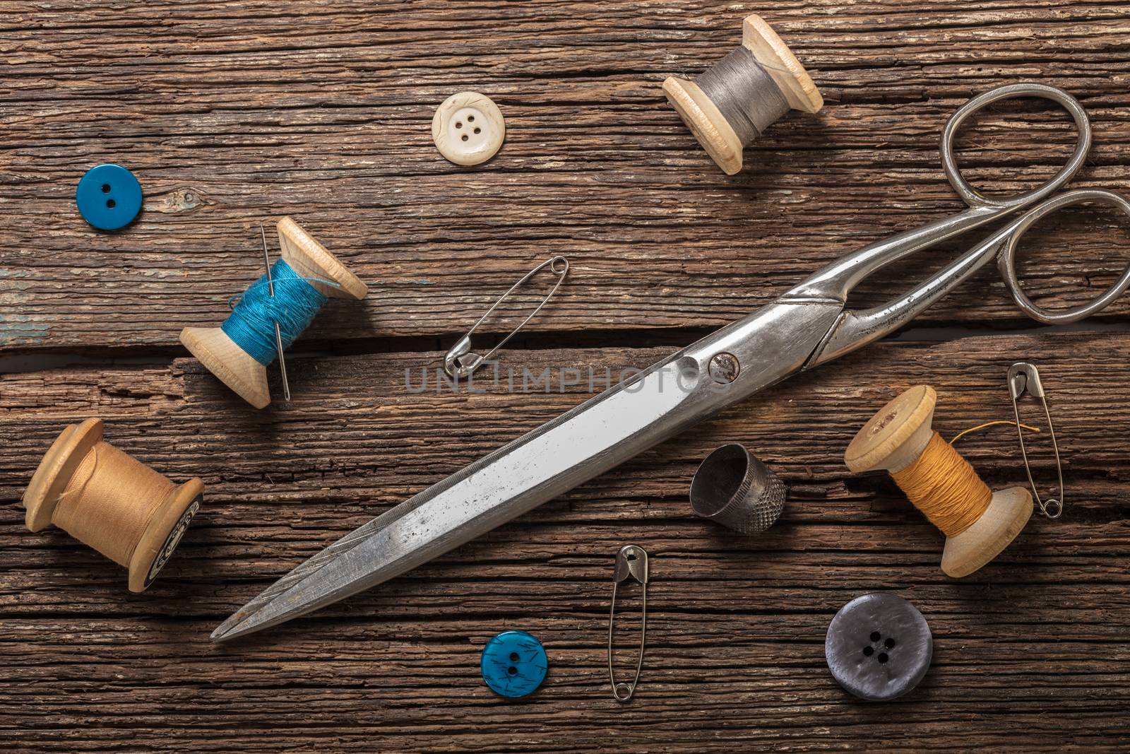 scissors and sewing accessories on a wooden background