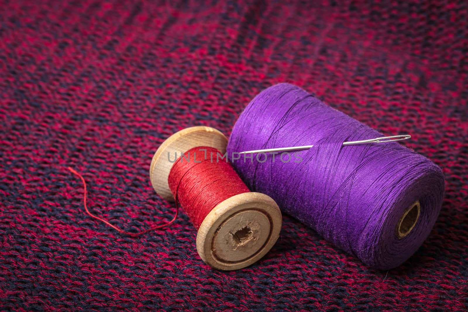 spools of colored threads against the background of knitted fabric