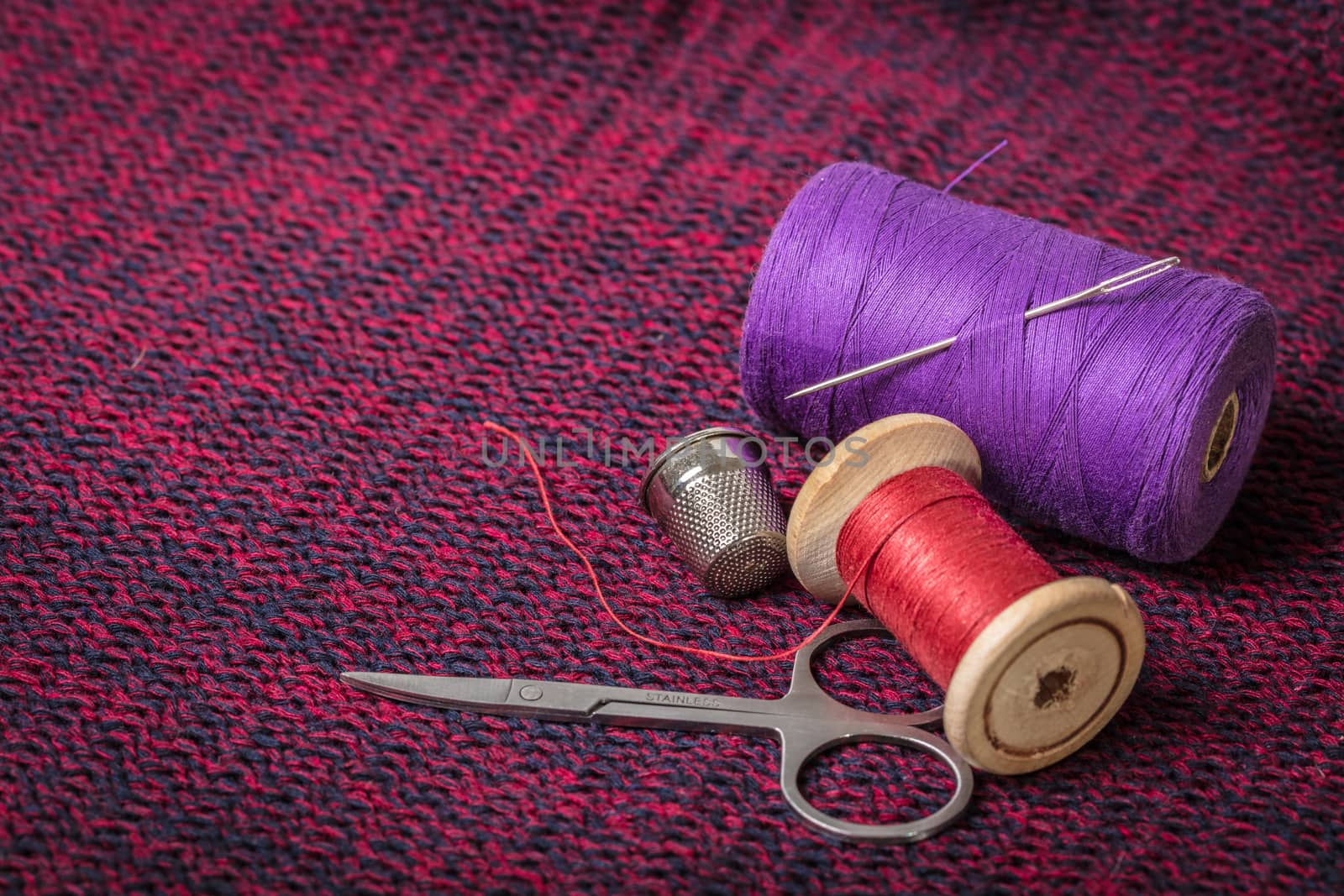 spools of colored threads against the background of knitted fabric