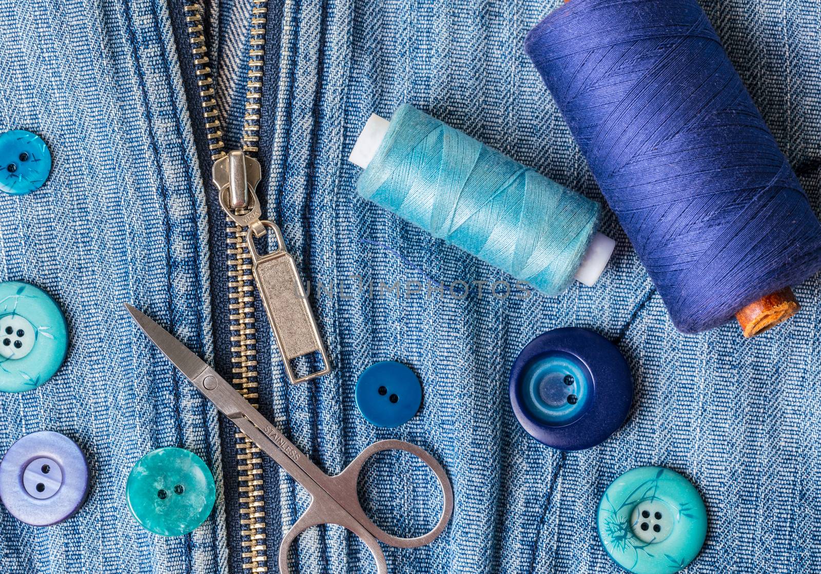 blue threads with buttons on the background of a denim jacket