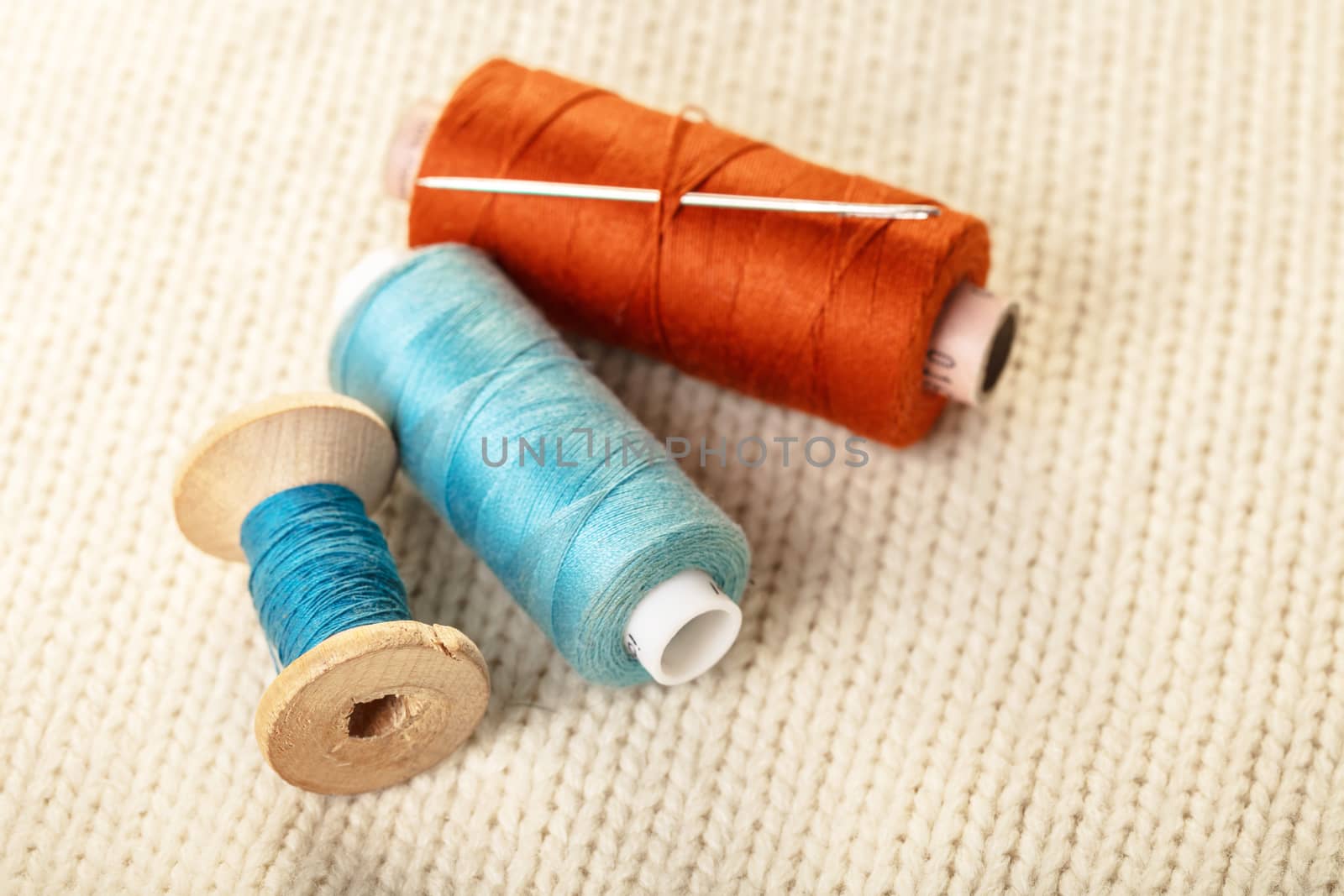 coils of colored thread on white knitted fabric