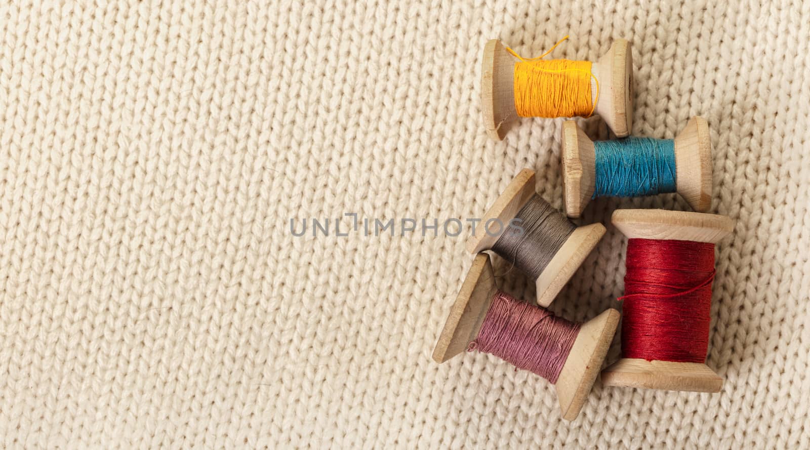 coils of colored thread on white knitted fabric