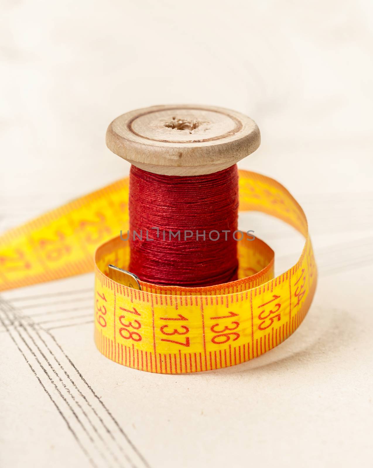 red thread and meter on background of paper pattern