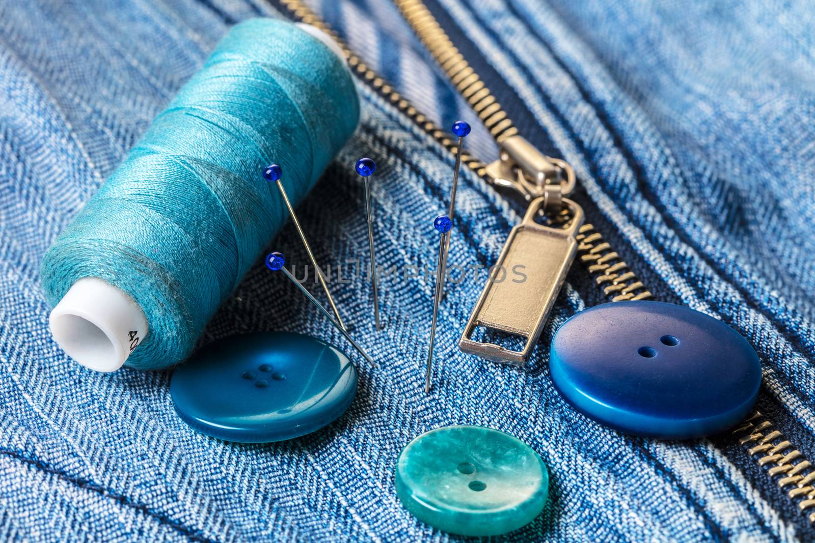 blue threads with buttons on the background of a denim jacket