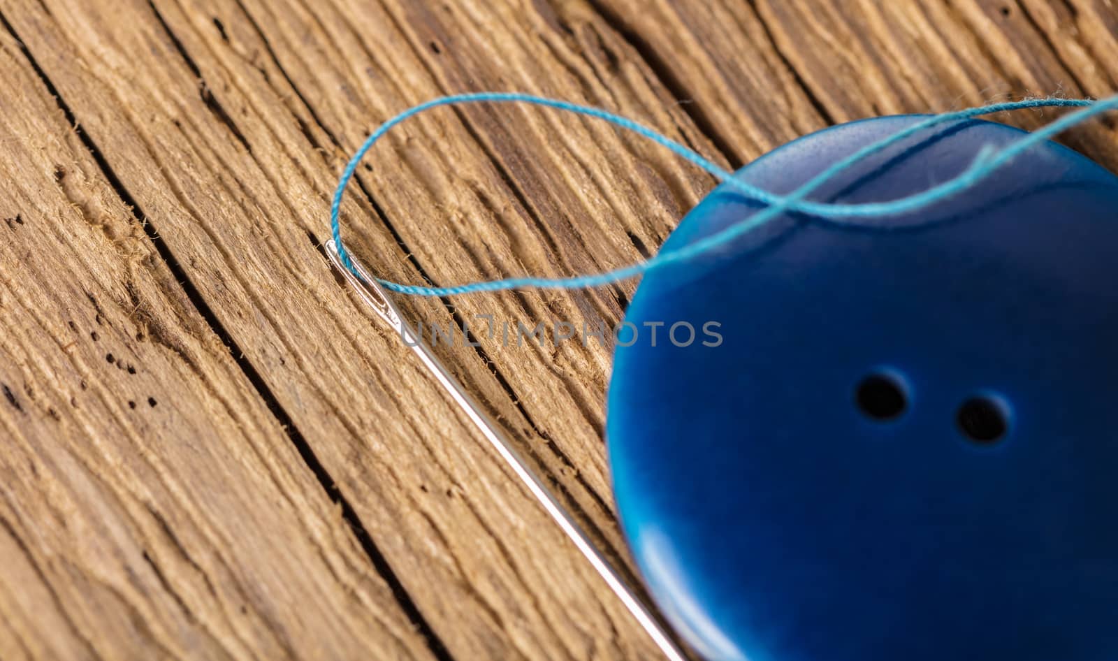 blue button close-up on a wooden background, top view