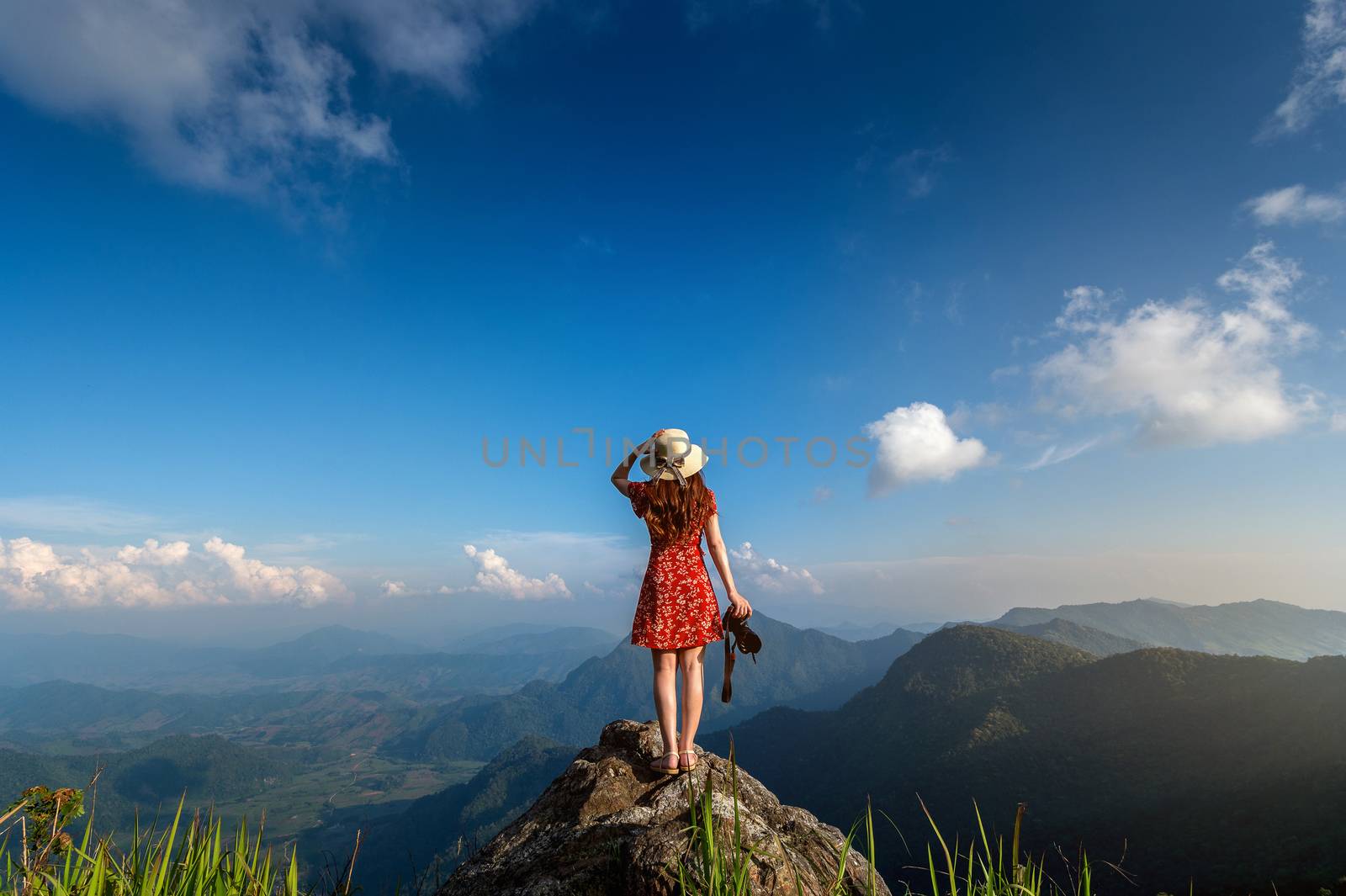 Woman hand holding camera and standing on top of the rock in nature. Travel concept. by gutarphotoghaphy