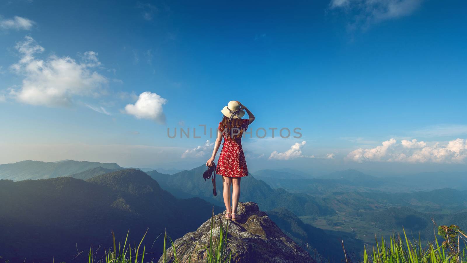 Woman hand holding camera and standing on top of the rock in nature. Travel concept. Vintage tone.