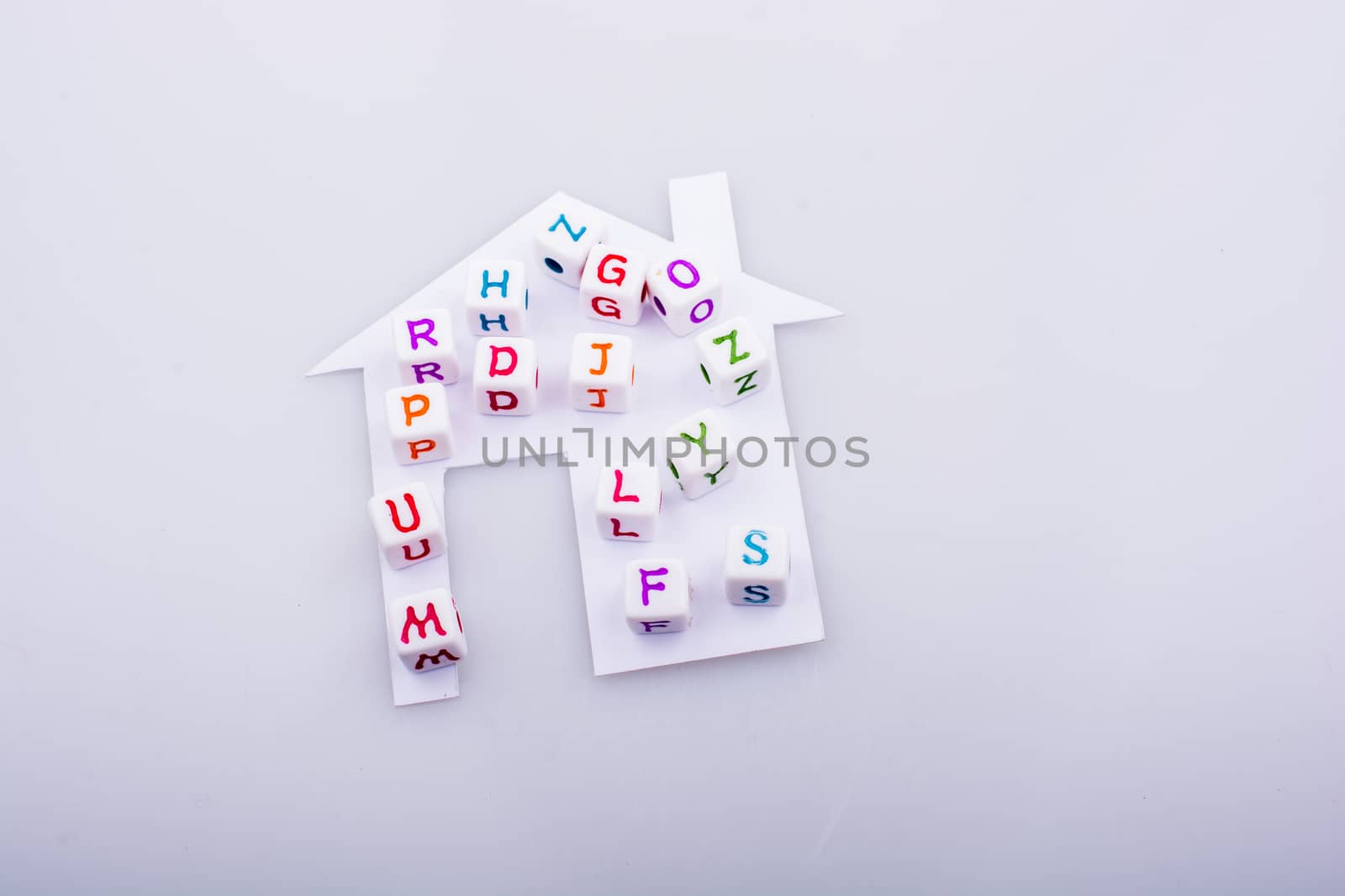 Letter cubes on house shape cut out of paper