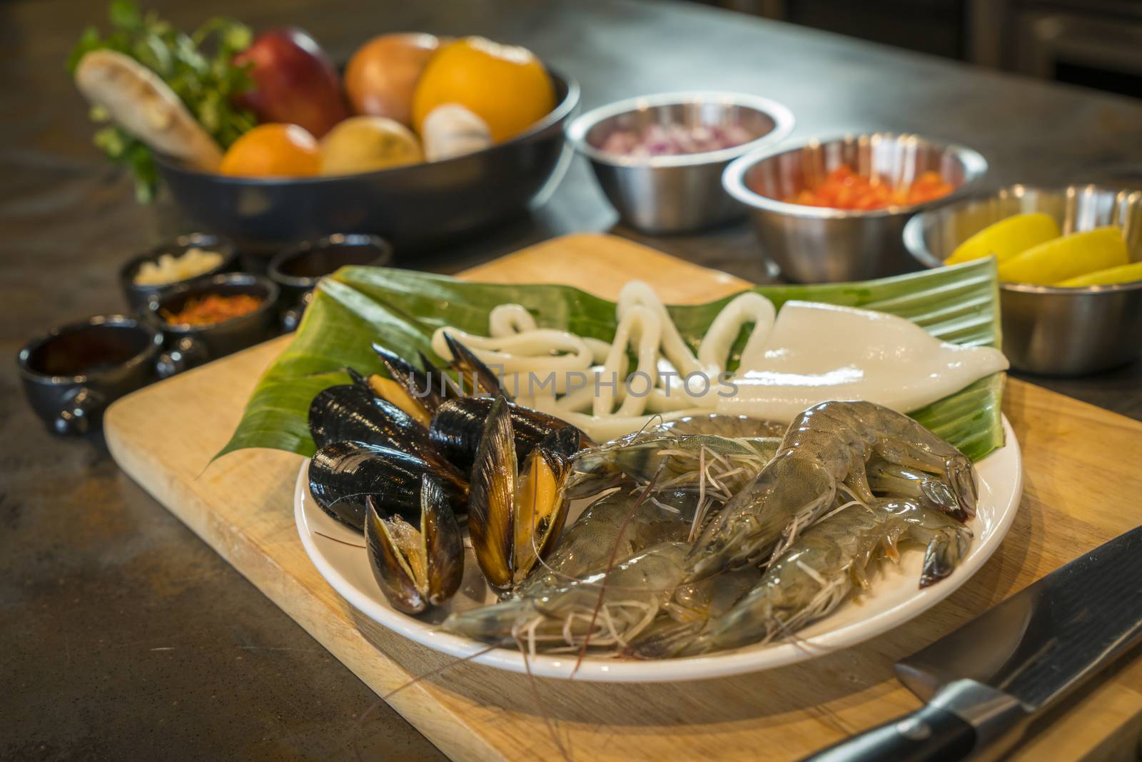 Raw seafood on plate with fruits and vegetables, healthy food, prawn, clam squid.