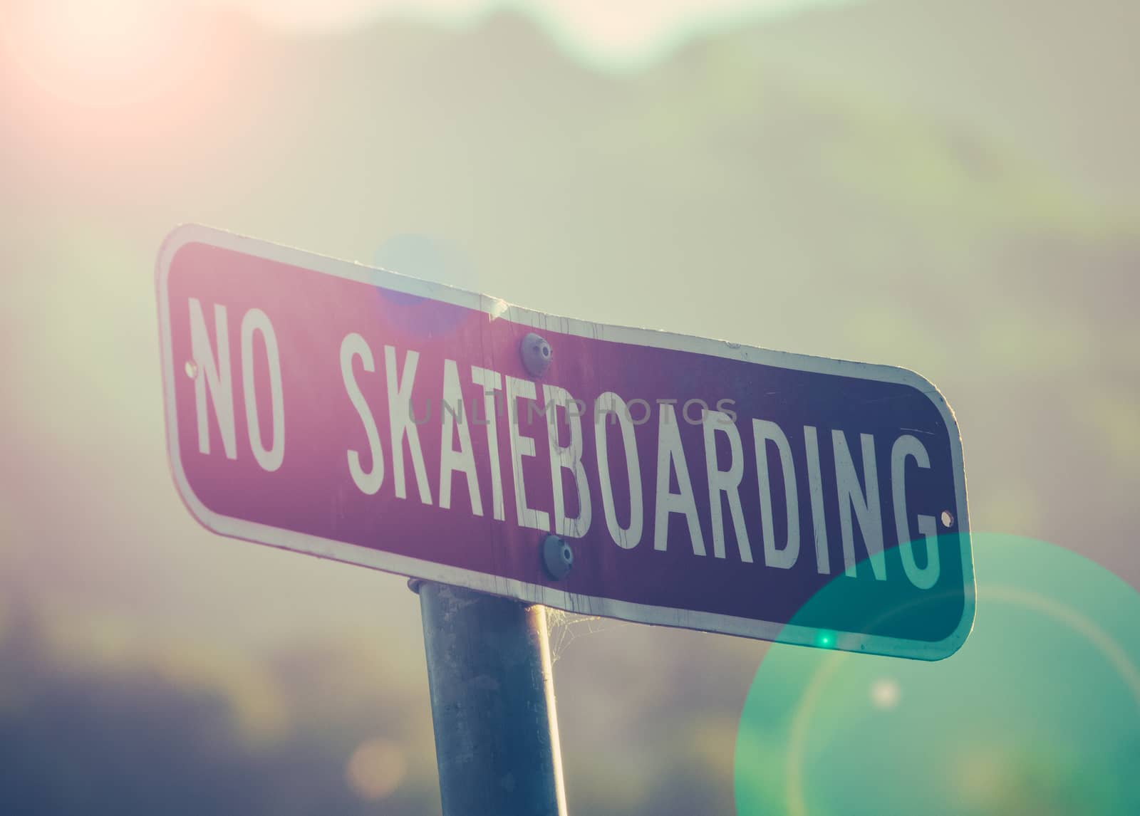 Retro Style Photo Of A No Skateboarding Sign At Sunset With Lens Flare