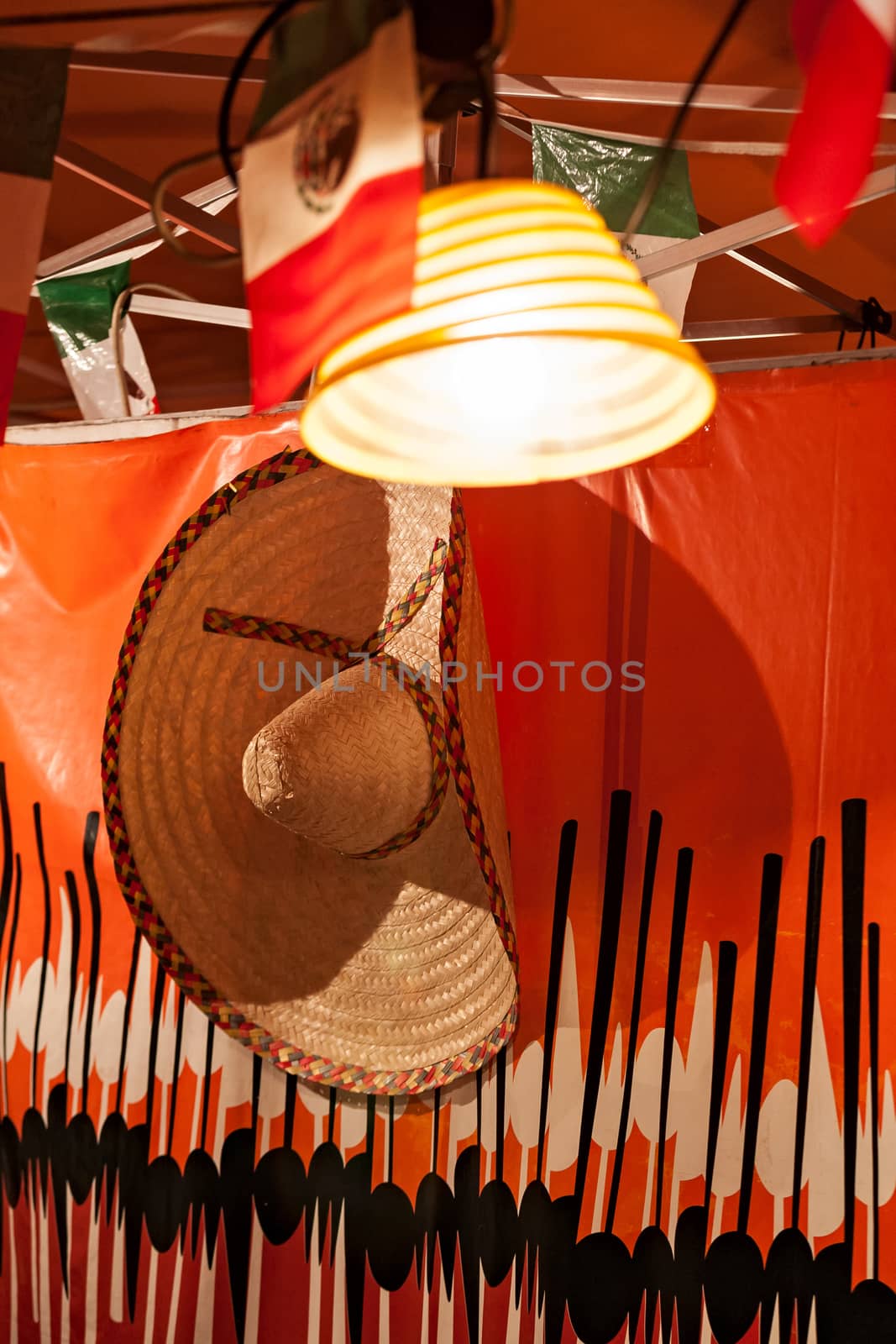 Mexican flags and sombrero hanged in a stand for a party
