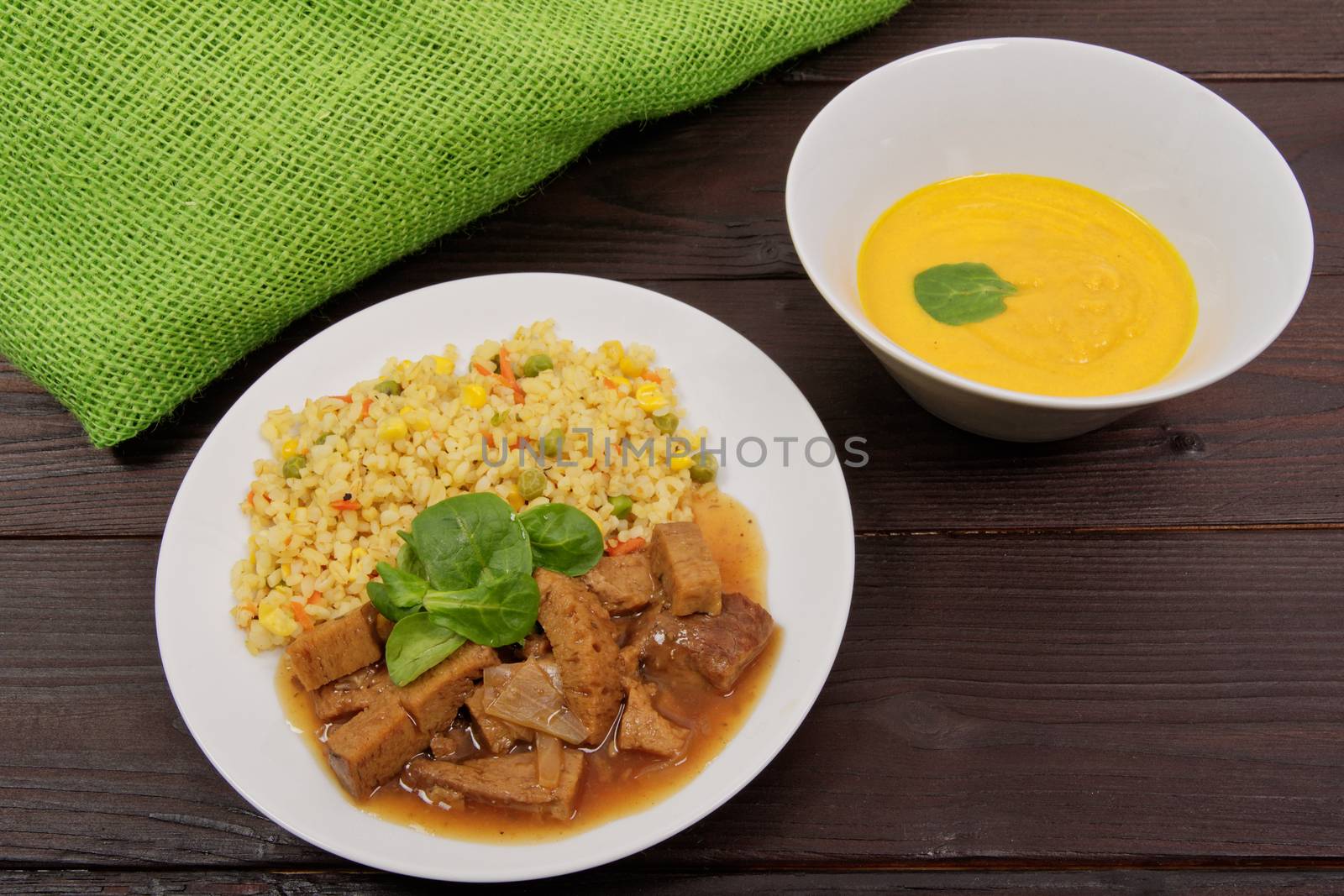 Tempeh with tomato sauce and millets on a wooden table