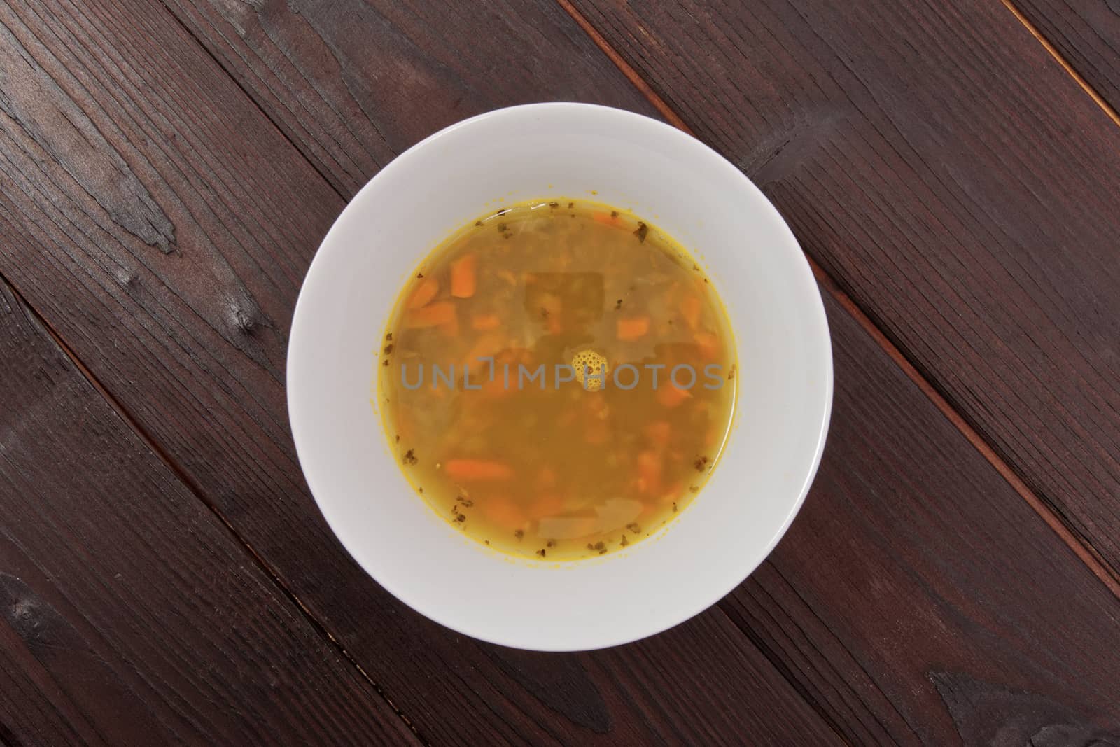 Lentil soup with carrots on a wooden table