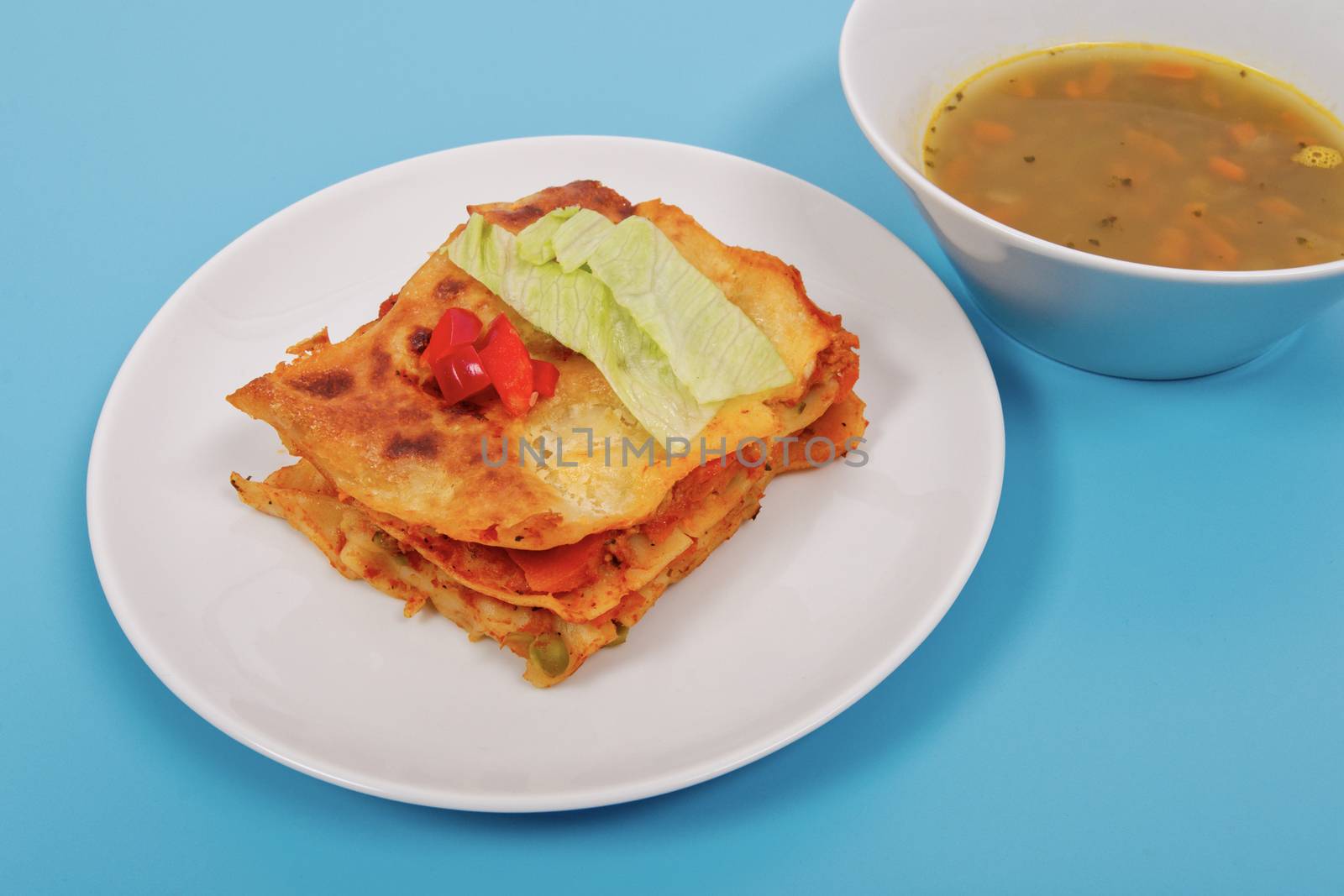 Lasagna with vegetables on a blue background