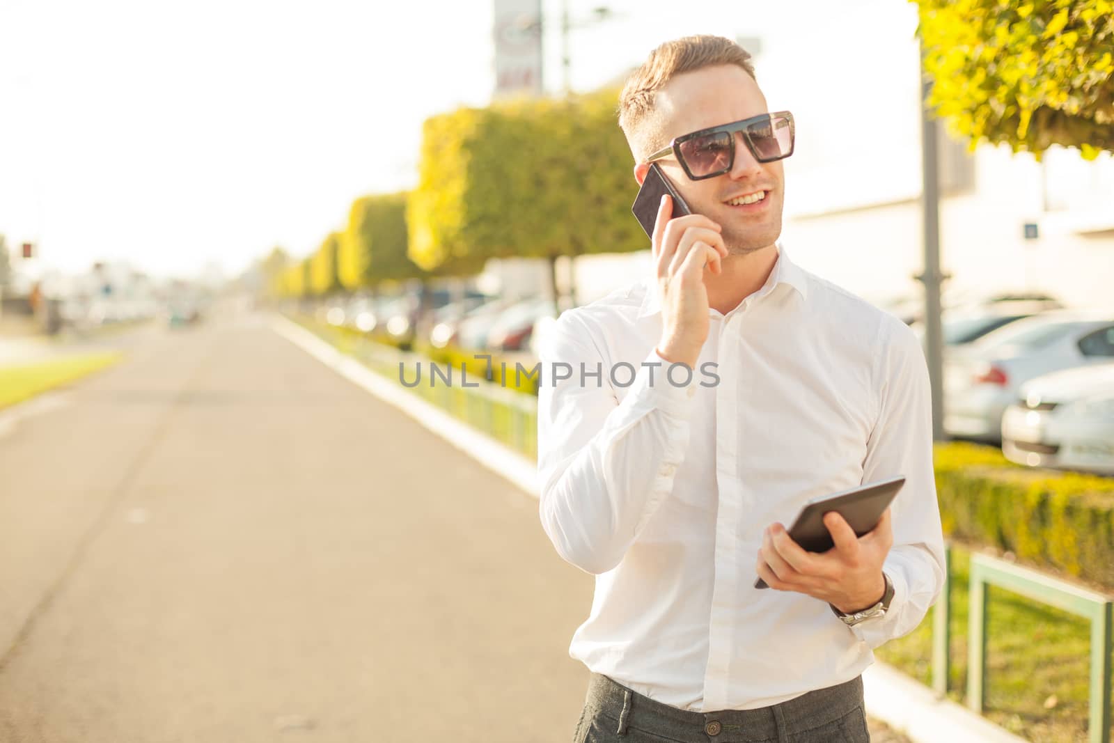 Businessman Man With Mobile Phone and Tablet computer in hands, In City, Urban Space