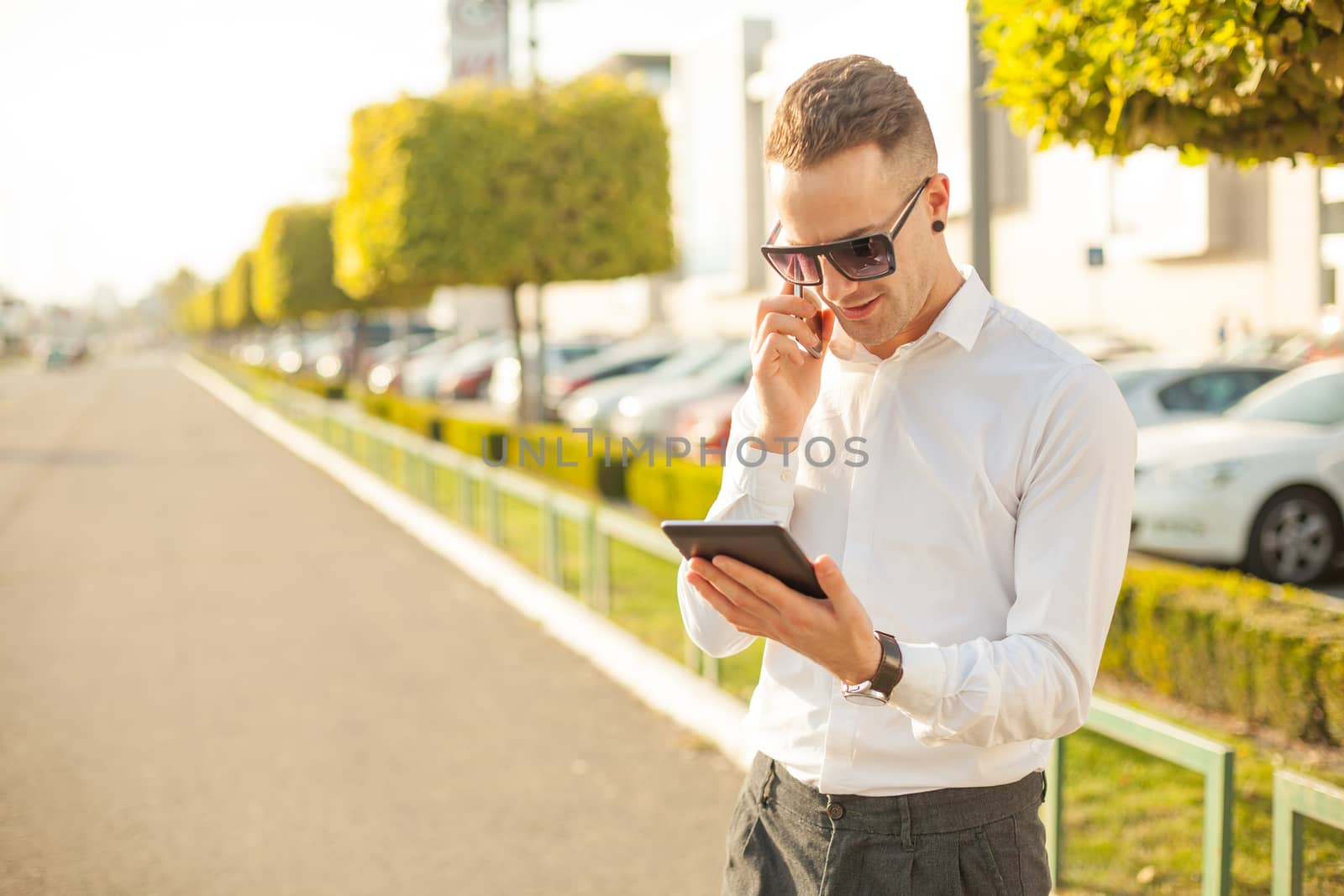 Businessman Man With Mobile Phone and Tablet computer in hands, In City, Urban Space