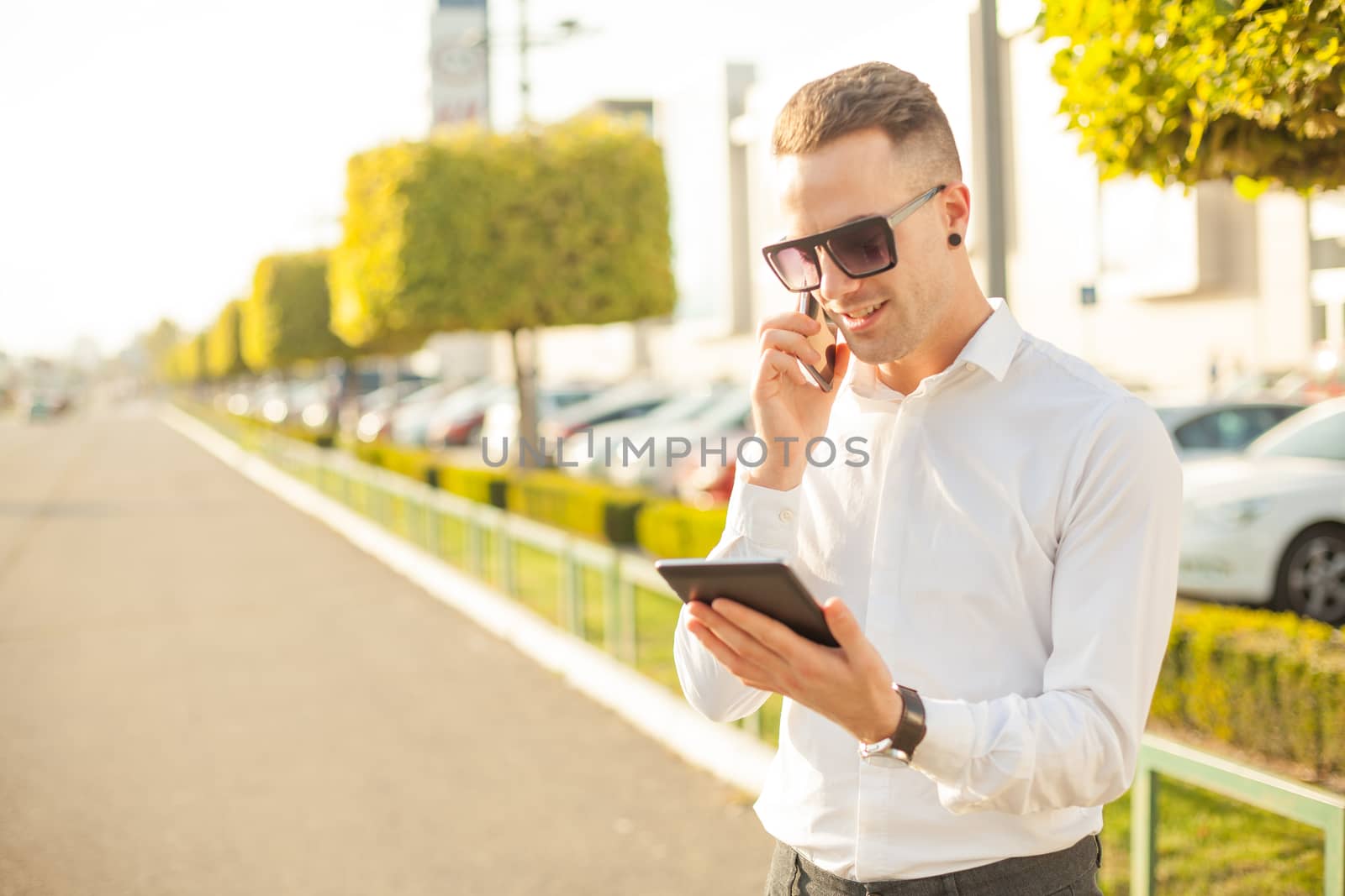 Businessman Man With Mobile Phone and Tablet computer in hands, In City, Urban Space