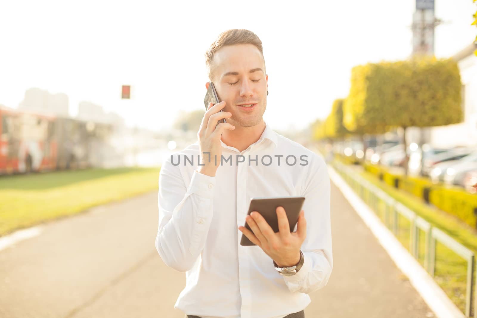 Businessman Man With Mobile Phone and Tablet computer in hands, In City, Urban Space