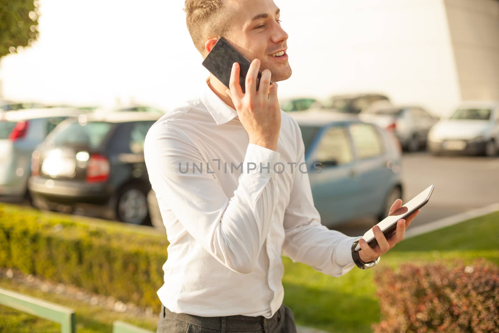 Businessman Man With Mobile Phone and Tablet computer in hands, In City, Urban Space