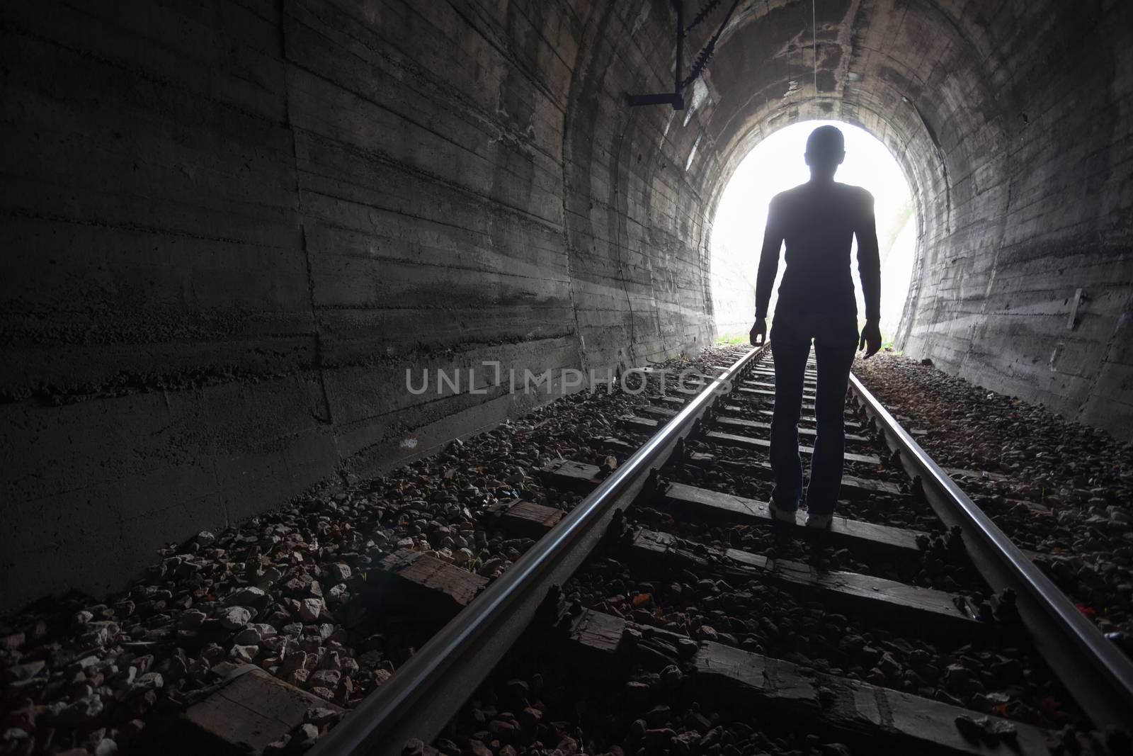 Man in a tunnel looking towards the light by adamr