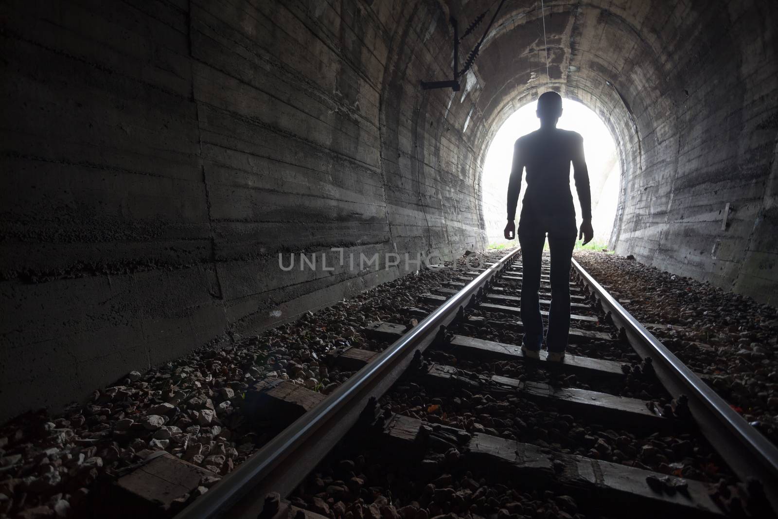 Man in a tunnel looking towards the light by adamr