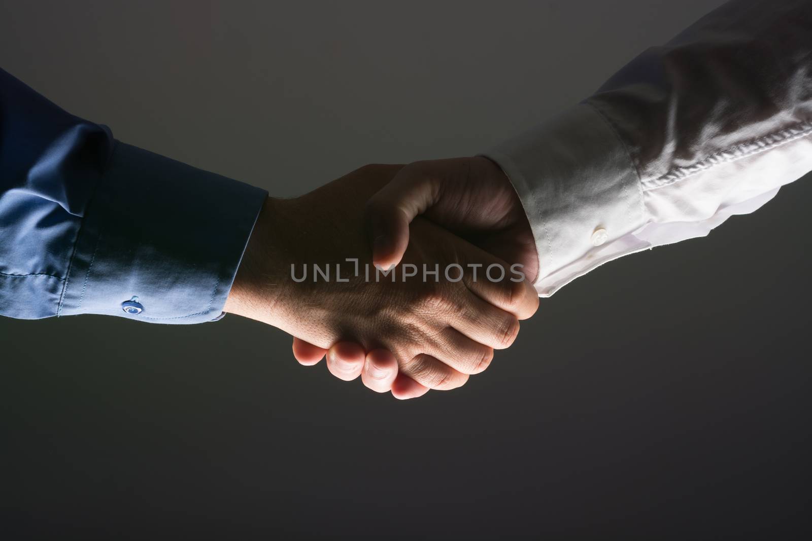 Two Businessman Handshake Handshaking between darkness and light