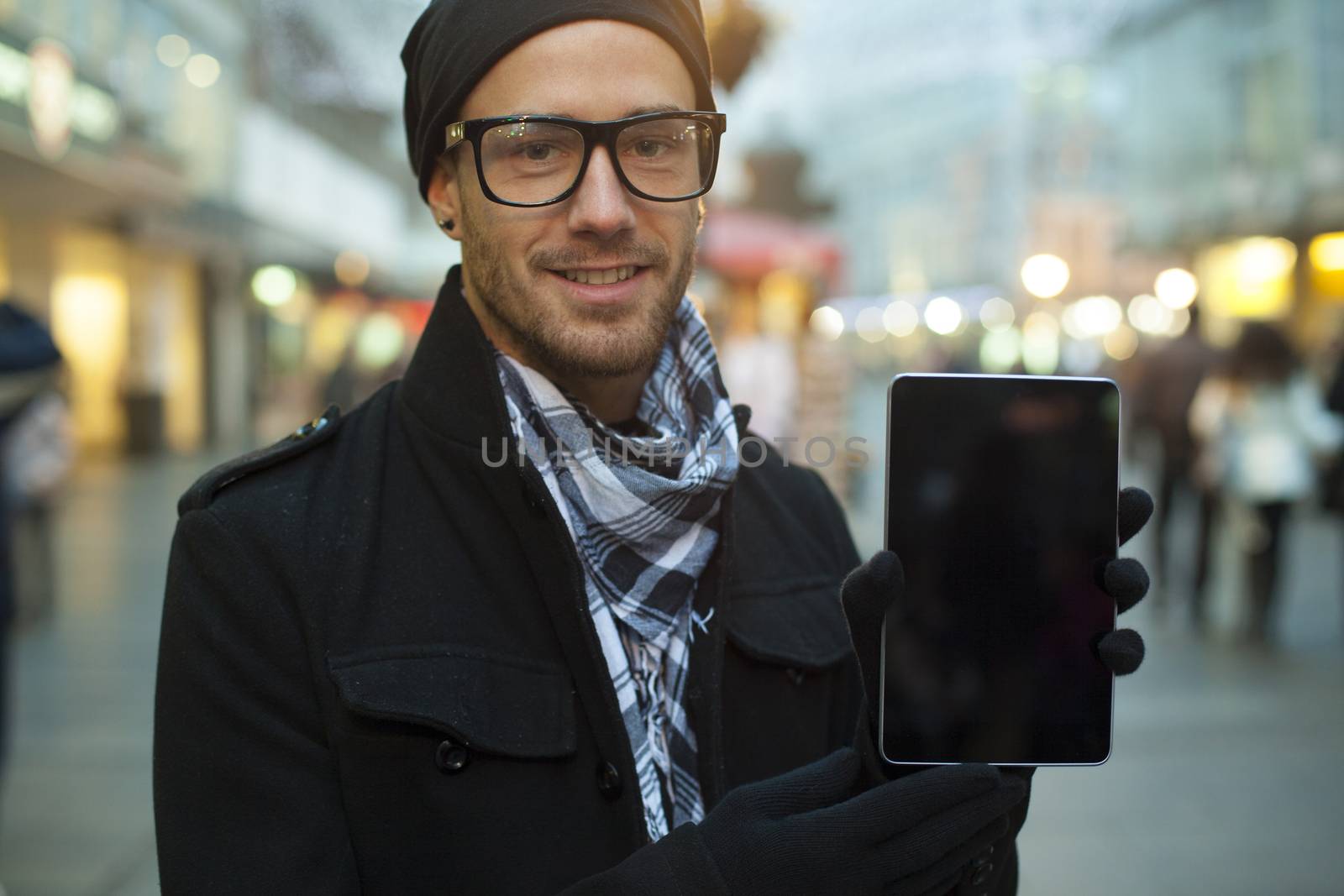 Urban man holdin tablet computer on street by adamr