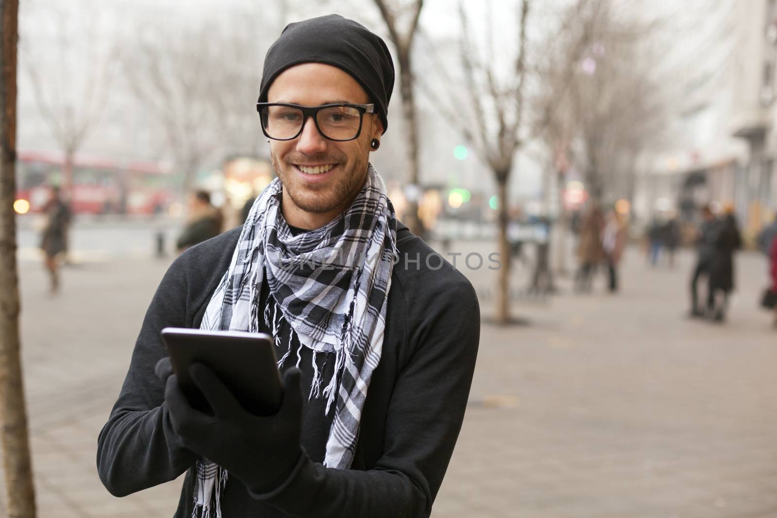 Young man reading messages and information using an i-pad tablet computer.