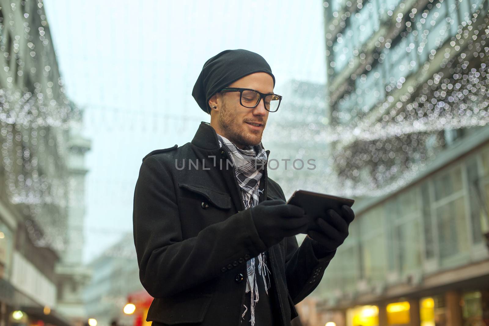 Young man reading messages and information using an i-pad tablet computer.